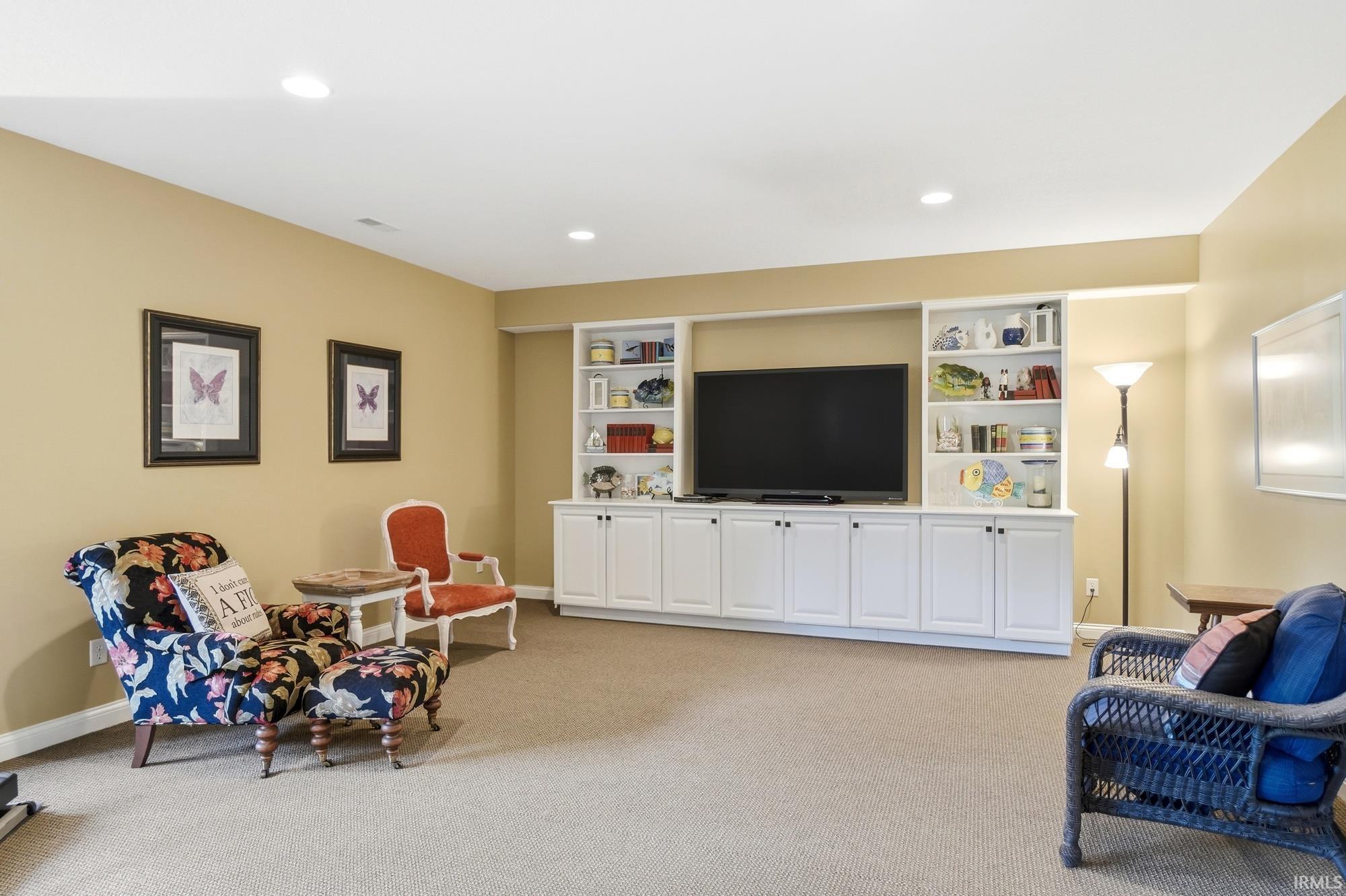 Integrated media center featuring open shelving and lower cabinetry, recessed lighting, and neutral carpeting