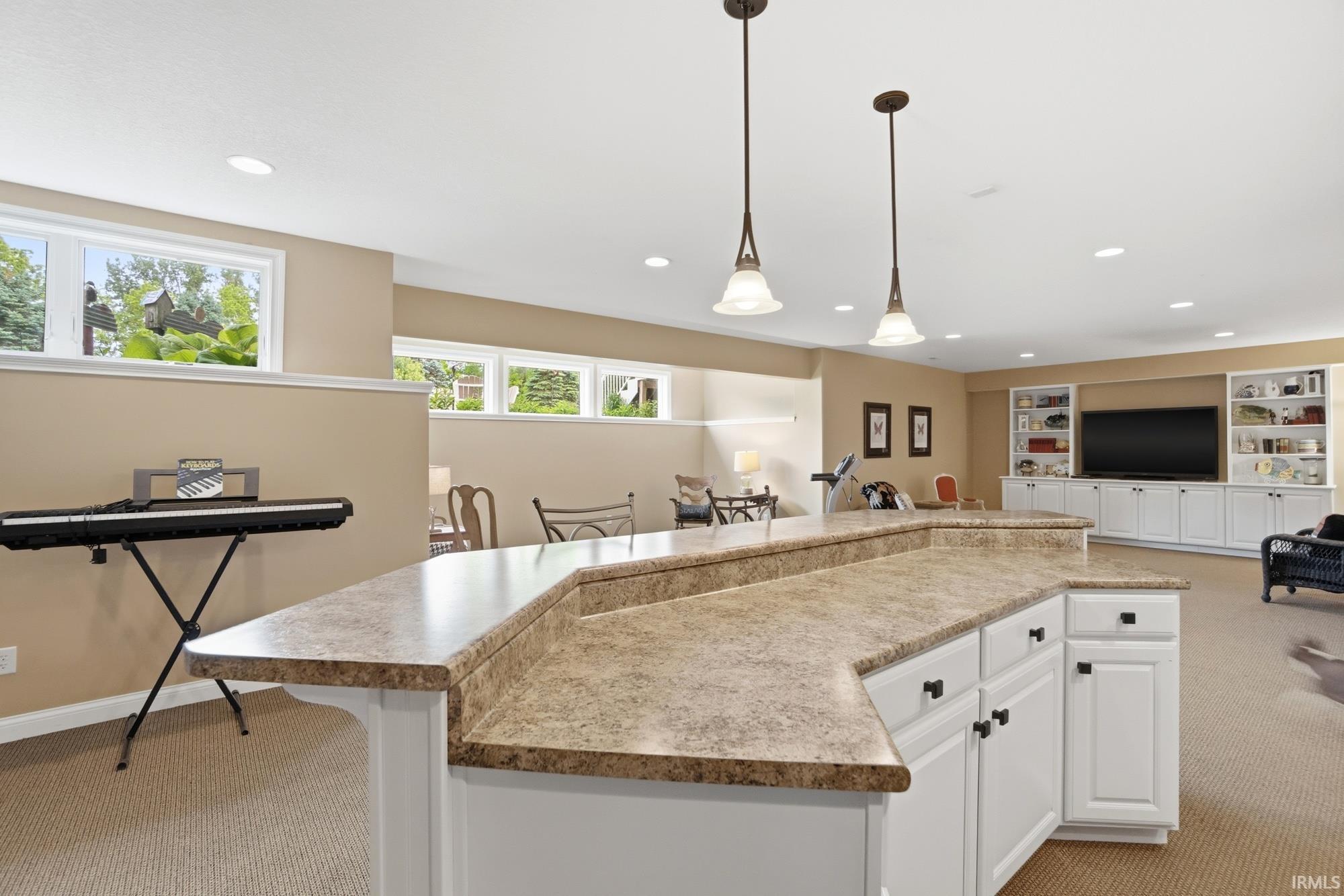 Extended countertop bar with white cabinetry and dark hardware