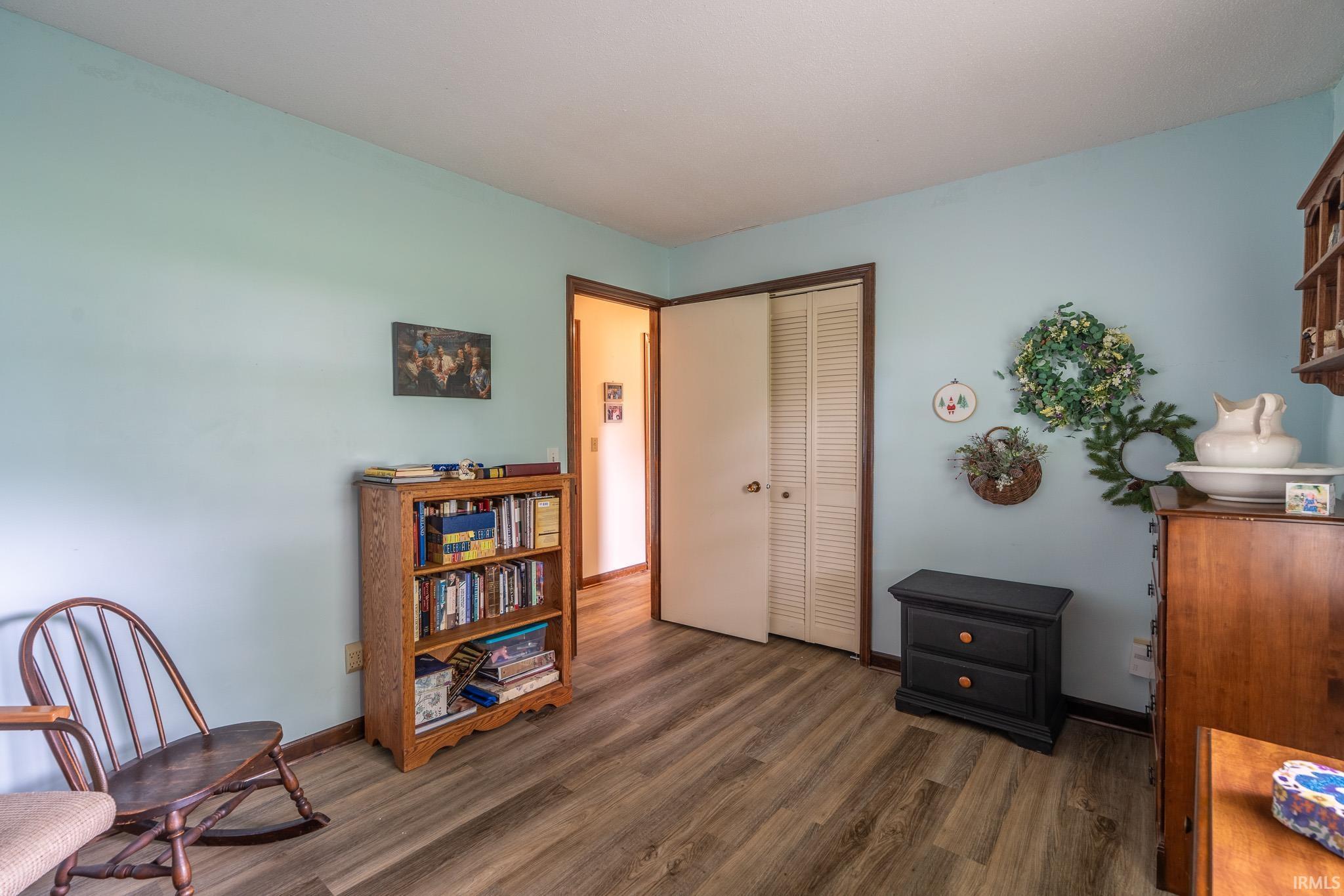 Room featuring wood-finish flooring, light blue walls, and a white ceiling