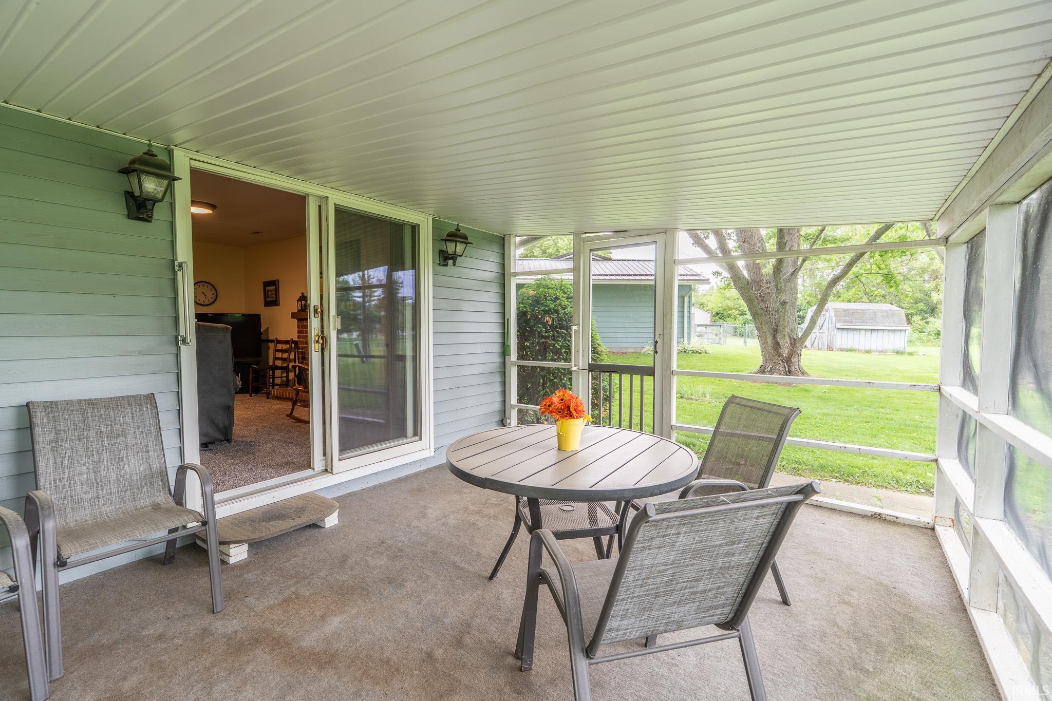 Spacious screened porch featuring a concrete slab floor, light blue horizontal siding, and an insulated ceiling