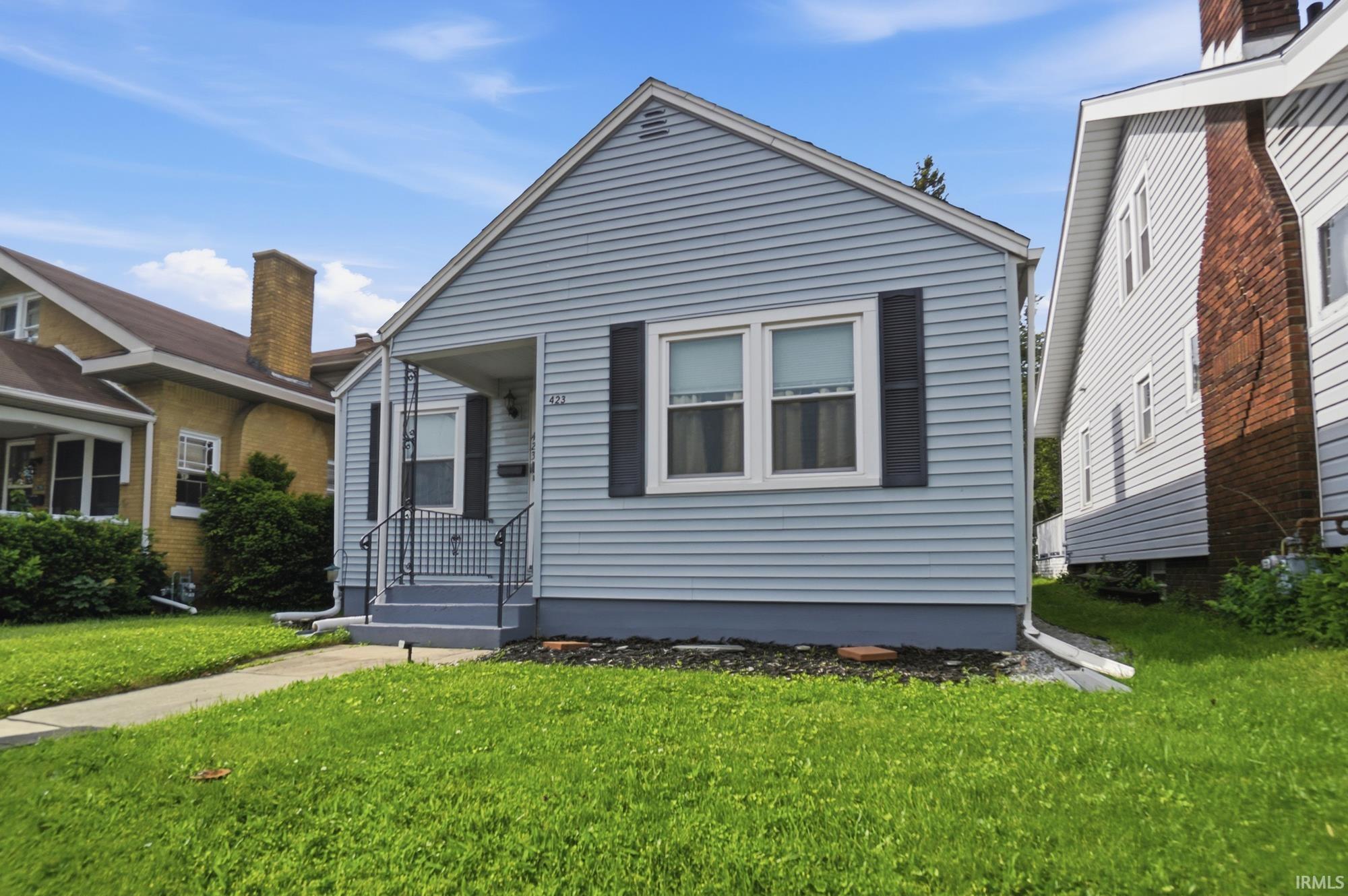 Light blue siding exterior featuring black window shutters and a covered front porch
