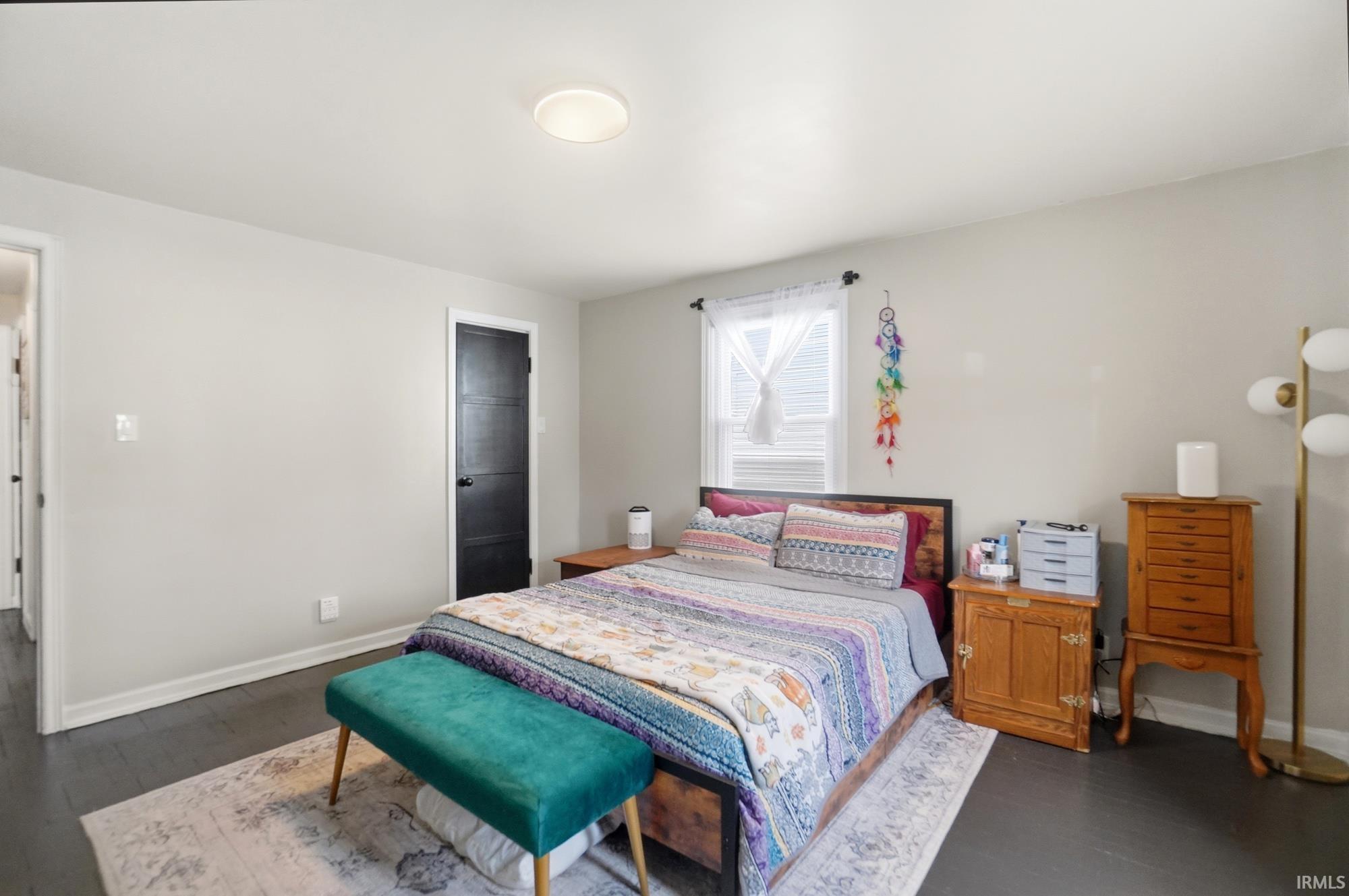 Bedroom with dark wood-finish flooring and light gray walls