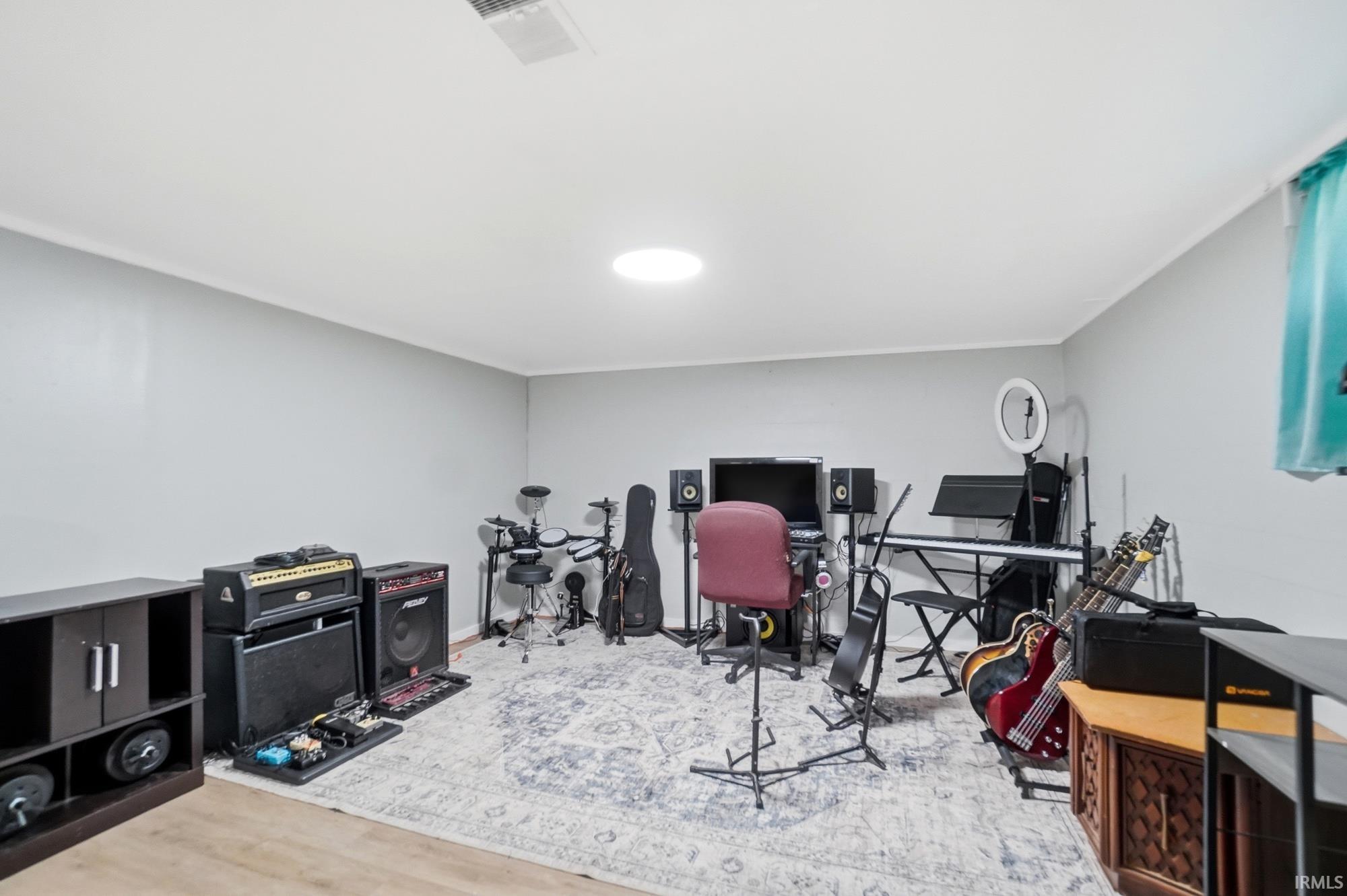 Spacious room featuring light gray walls, white baseboards, and a white ceiling with a circular light fixture