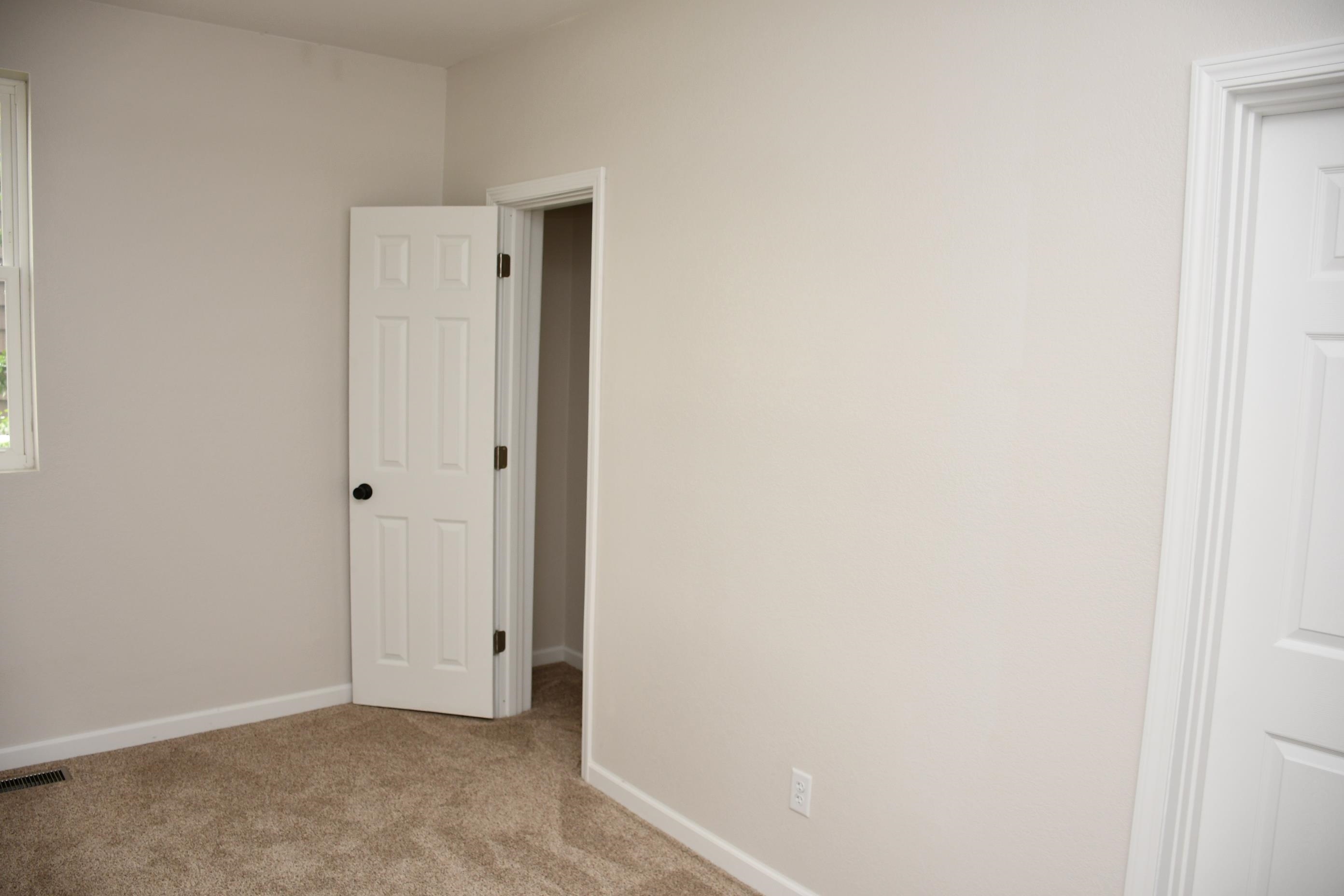 Neutral-toned walls and plush carpeting complement the white trim and six-panel interior doors