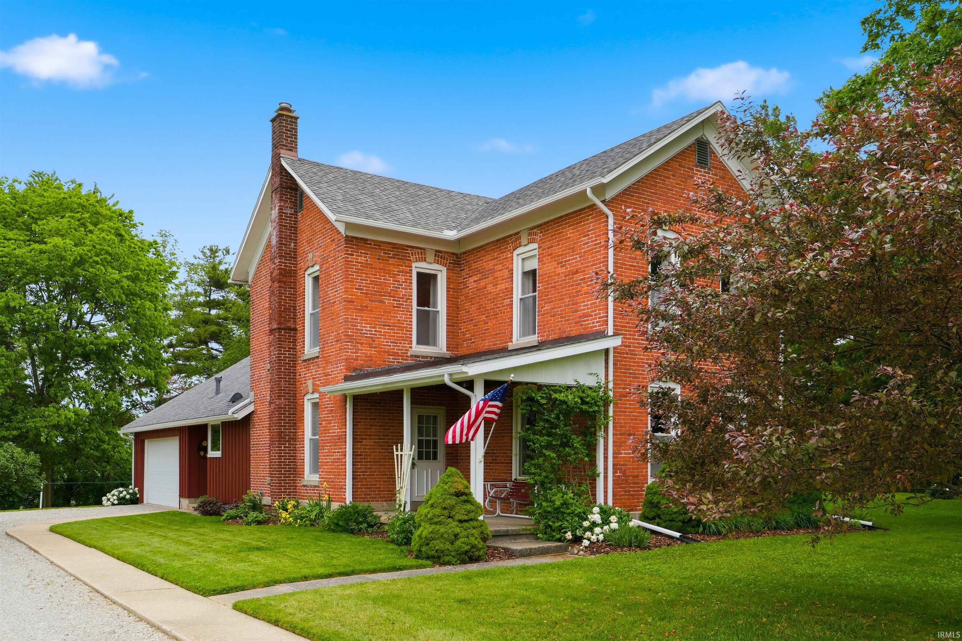 Brick exterior featuring a covered front porch with a white railing