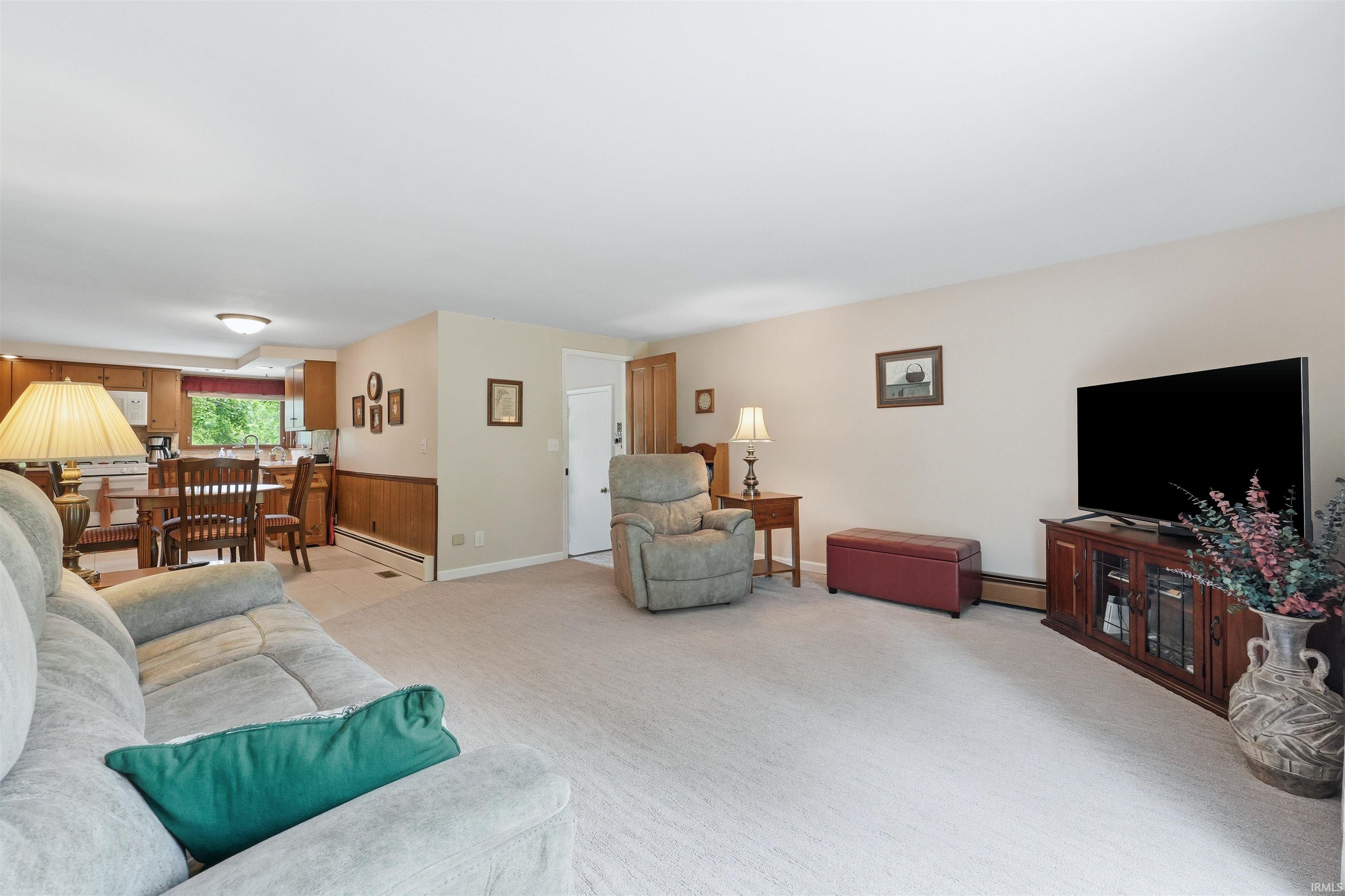 Spacious living area featuring neutral carpeting and light-toned walls