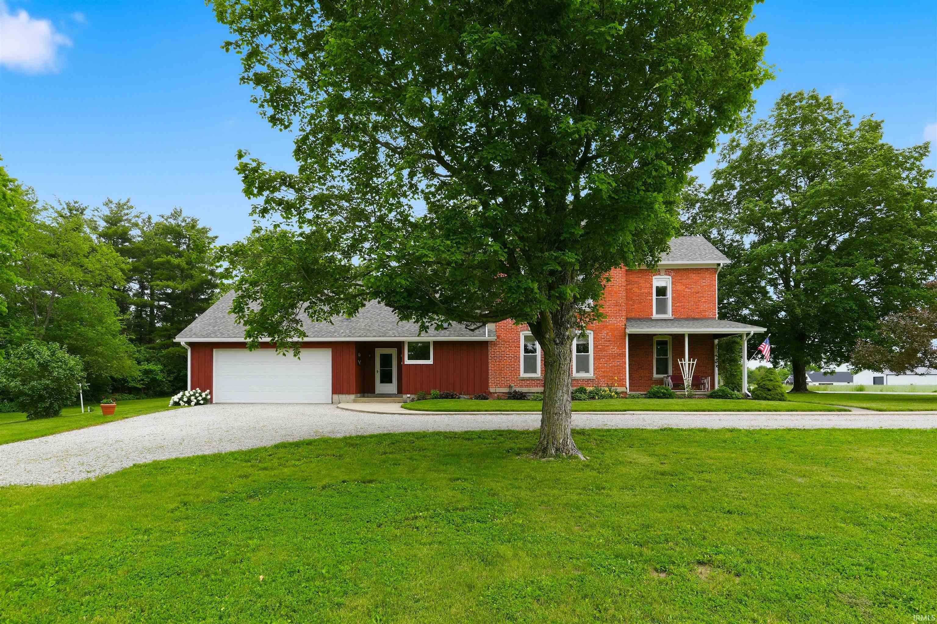 Brick-front residence featuring a two-story design with a covered porch
