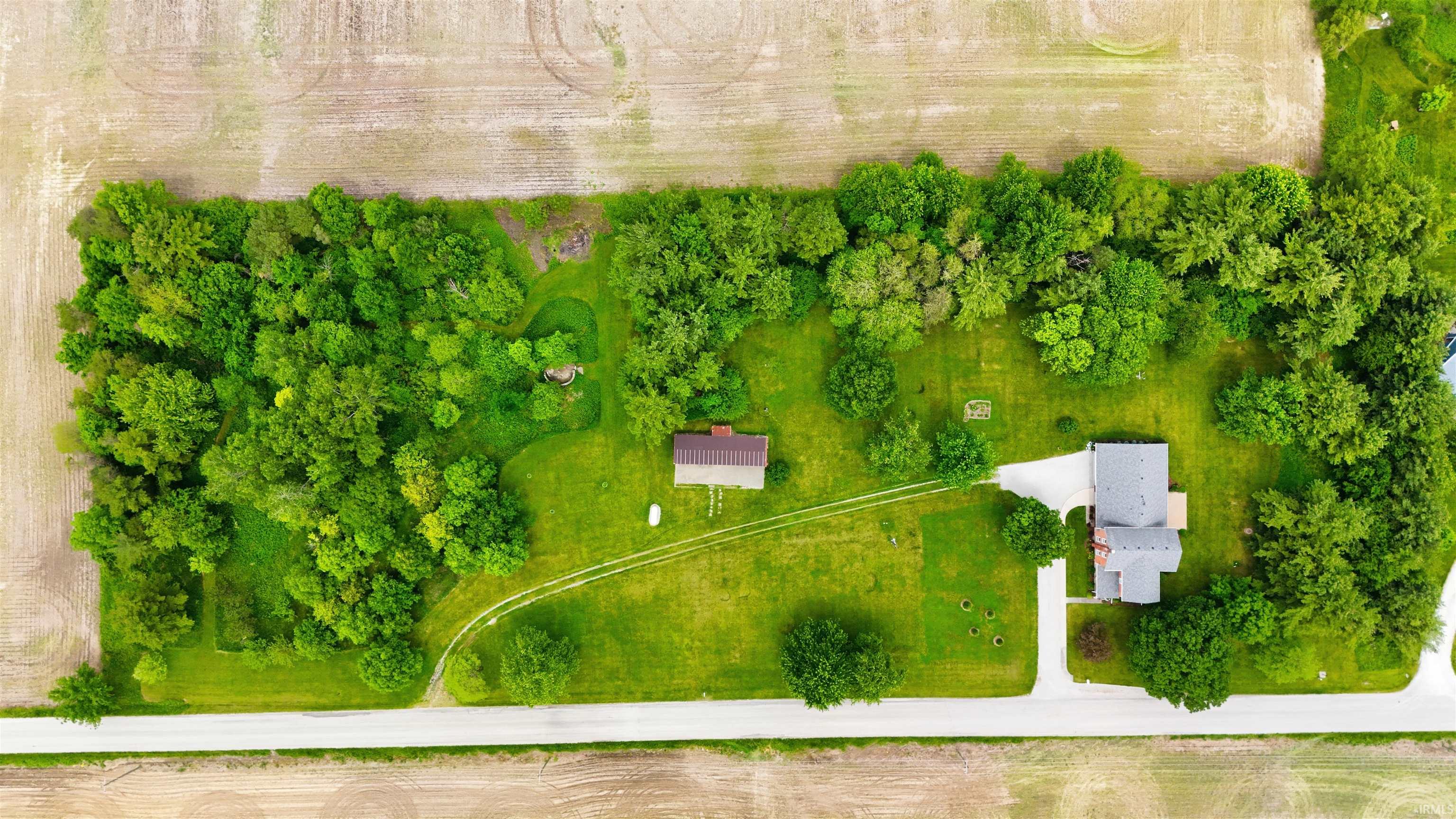 Aerial perspective showcasing a property surrounded by mature trees