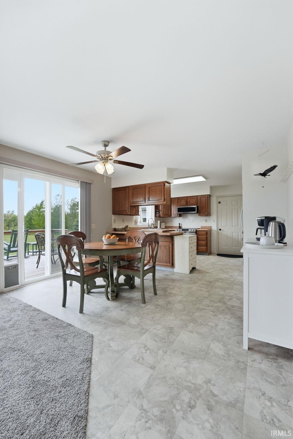 Open concept kitchen featuring wood-finish cabinetry, a central island, and stone-look flooring