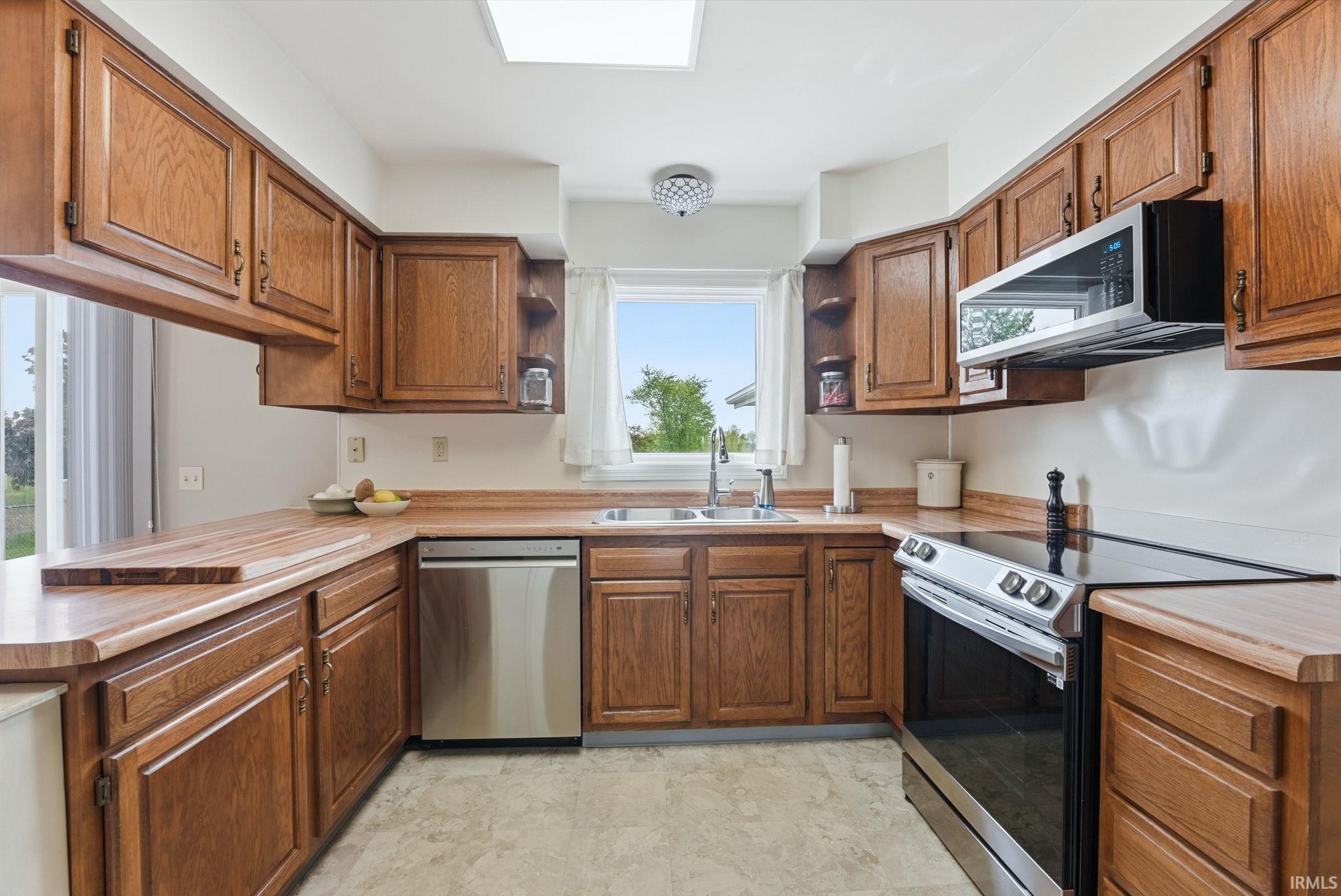 U-shaped kitchen featuring wood cabinetry and wood-finish countertops