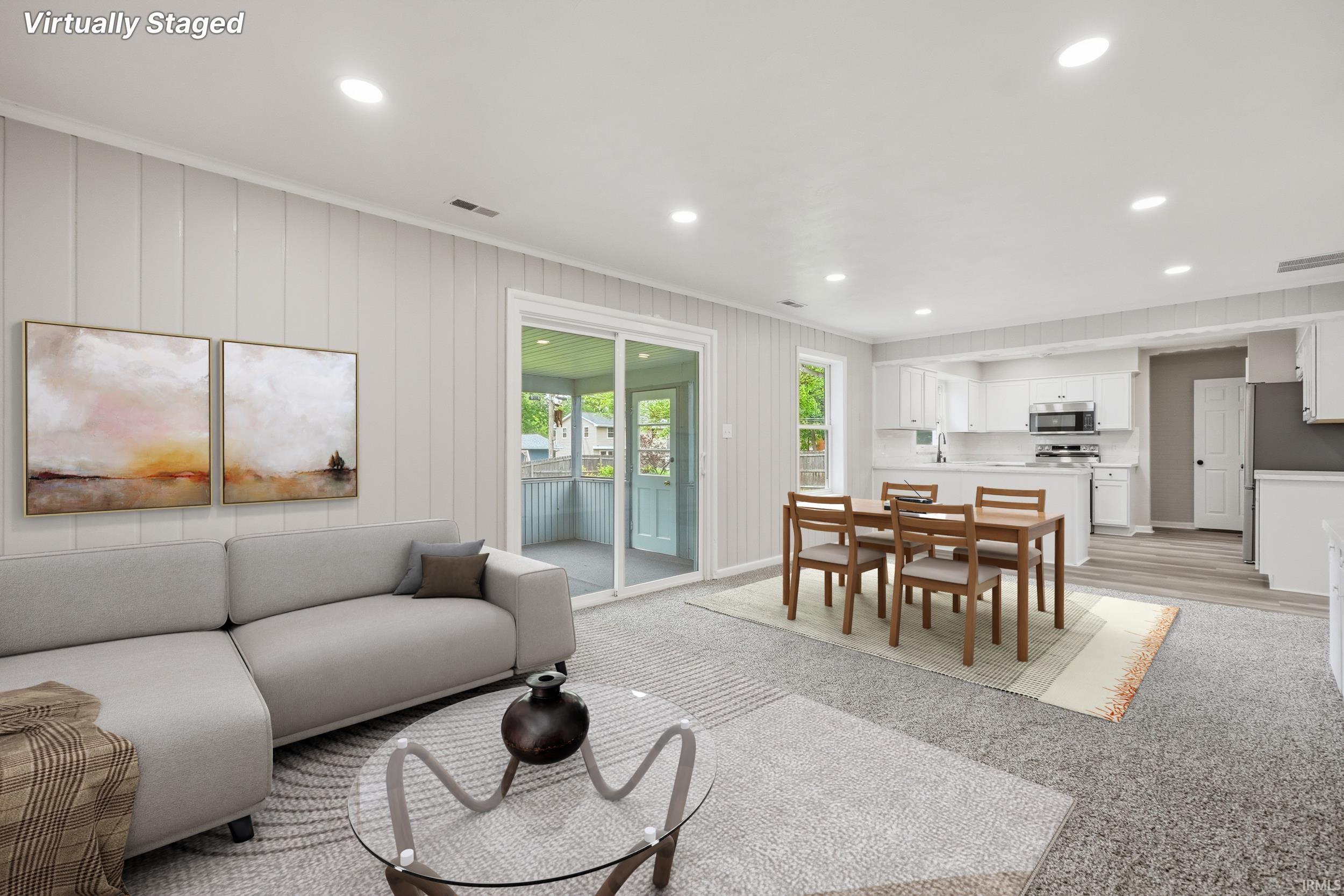 Open-concept living space featuring recessed lighting and vertical plank wall accents
