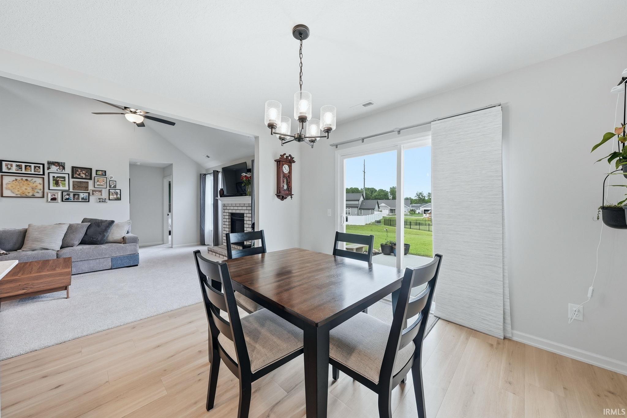 Dining area with wood-finish flooring and contemporary chandelier
