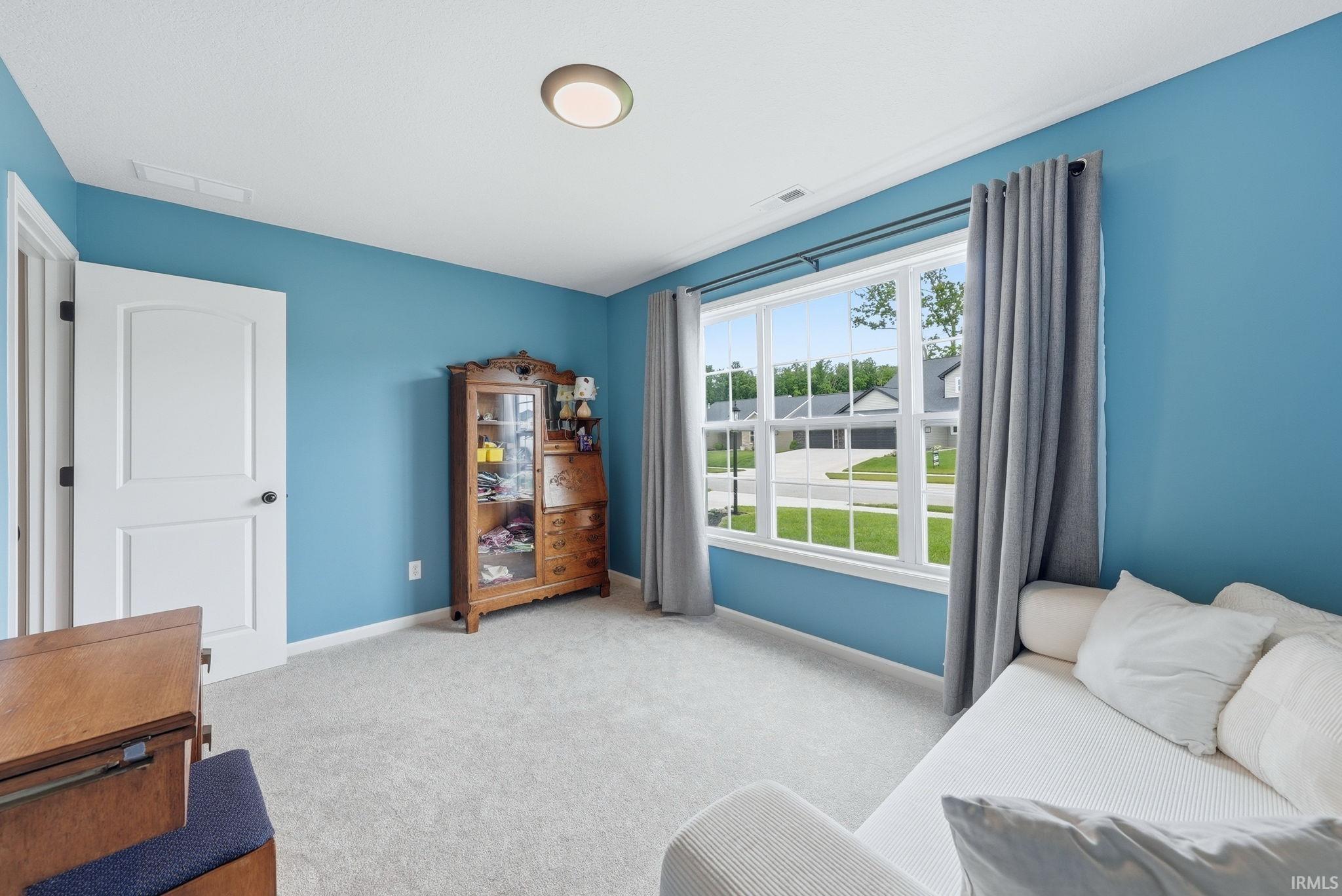 Room featuring light blue walls and neutral carpet flooring