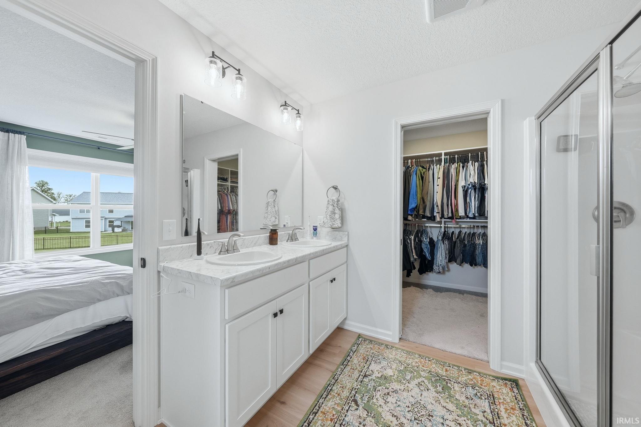 Dual vanity featuring undermount sinks, chrome fixtures, and a large wall-mounted mirror