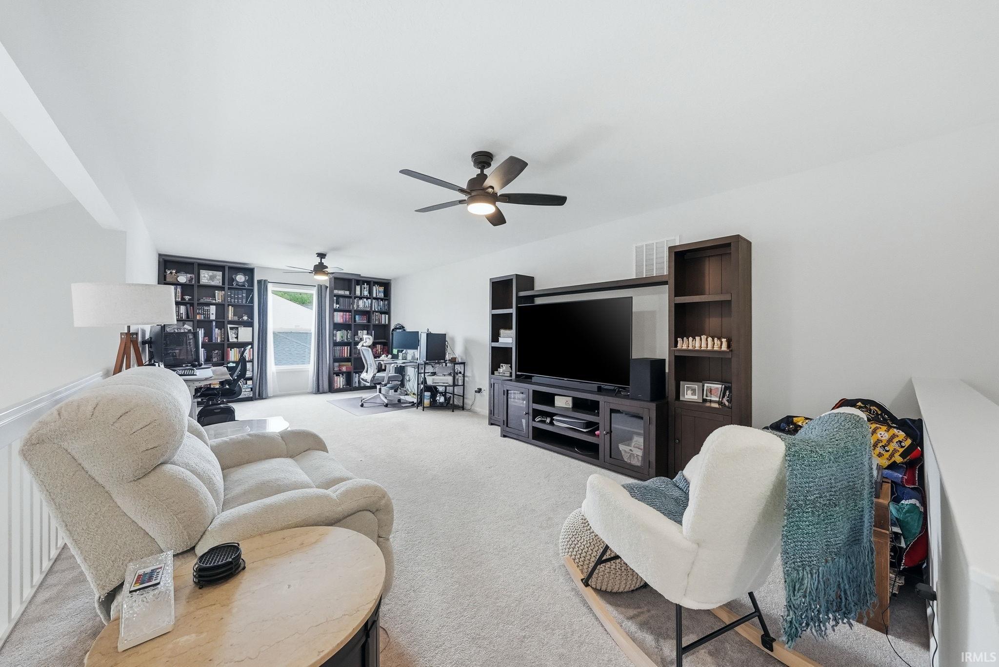 Spacious loft area featuring light-toned carpeting and neutral wall finishes
