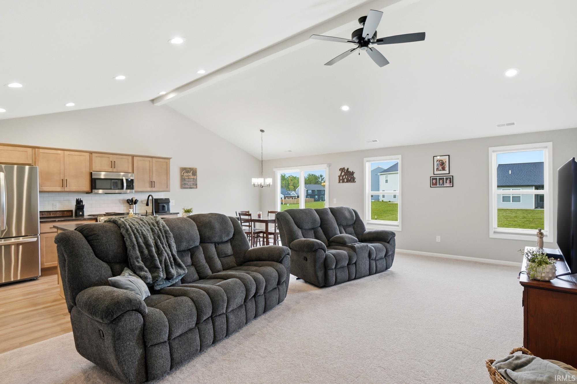 Open-concept living space with vaulted ceiling and recessed lighting