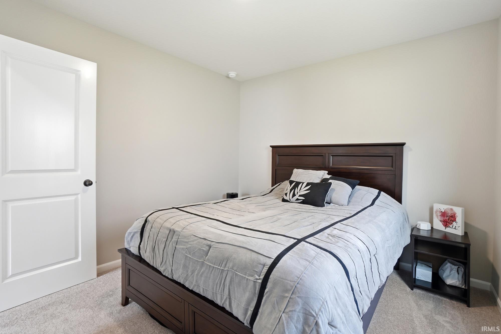 Neutral-toned walls complement the light beige carpeting in this bedroom