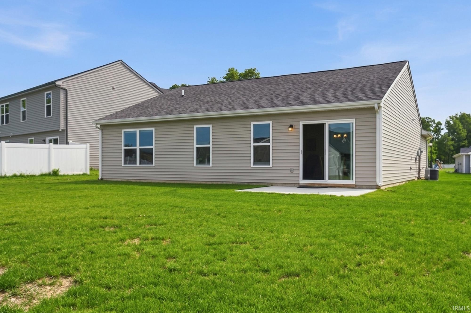 Expansive grassy yard backing to a privacy fence