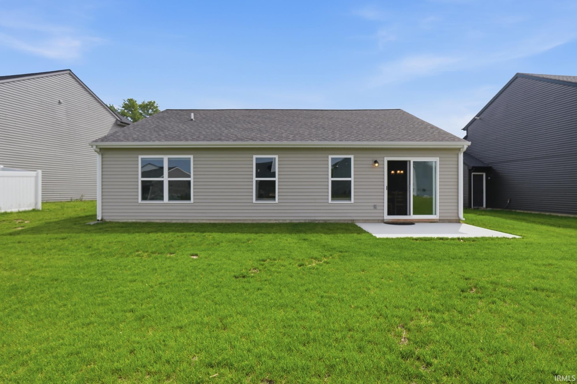 Expansive green lawn with a concrete patio