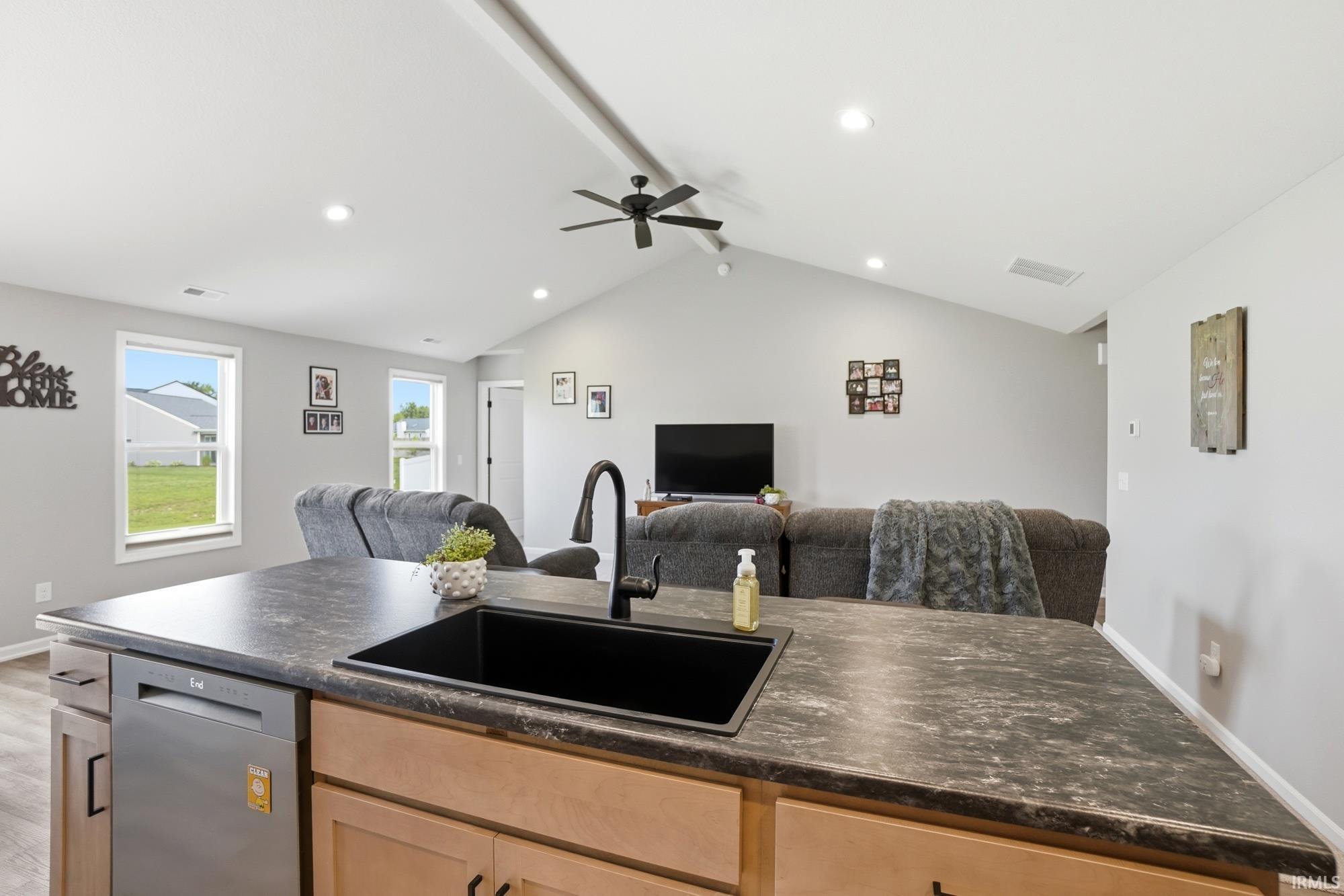 Kitchen island featuring a black sink and a modern black faucet