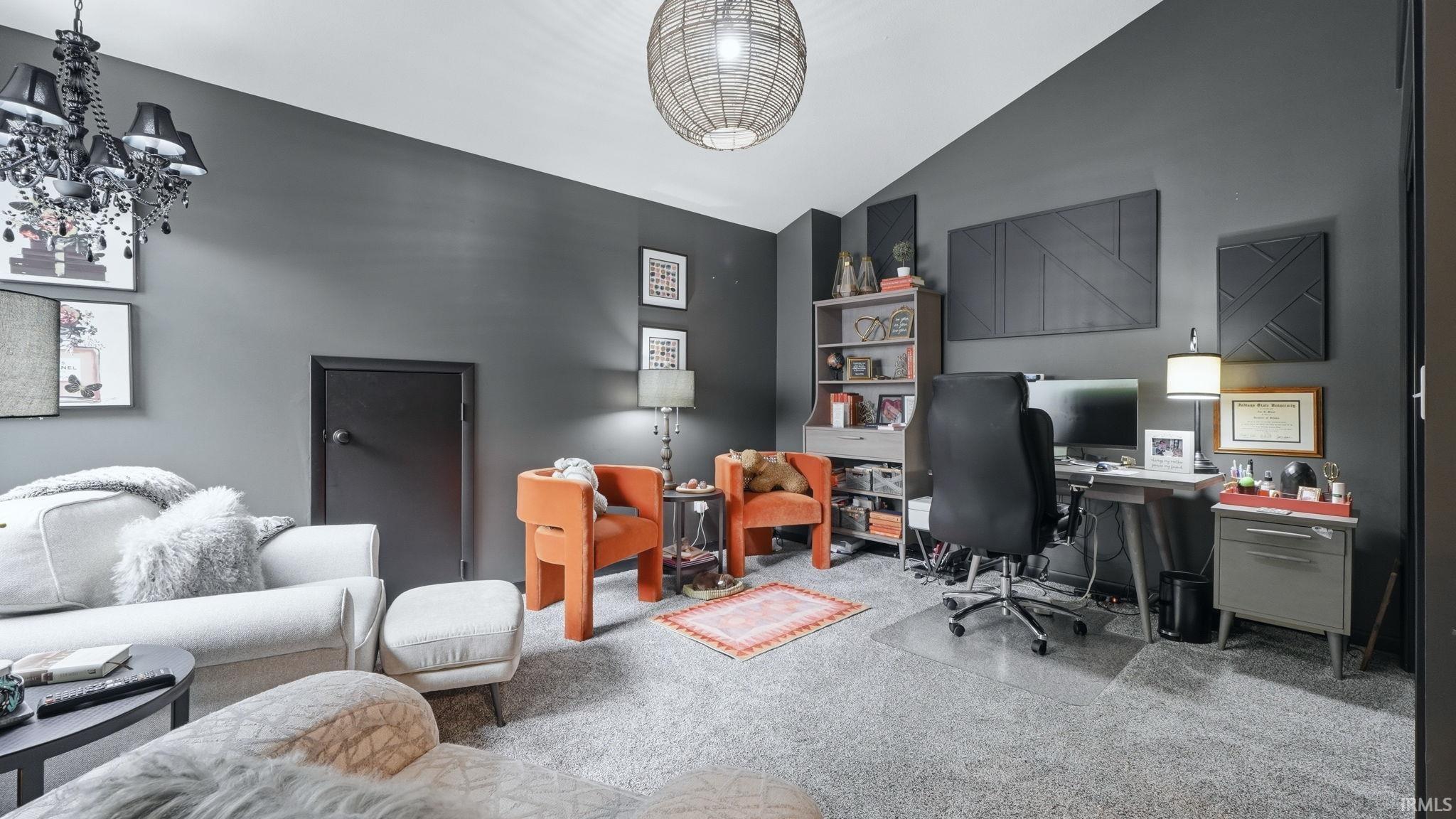 Carpeted room with a vaulted ceiling and dark gray walls