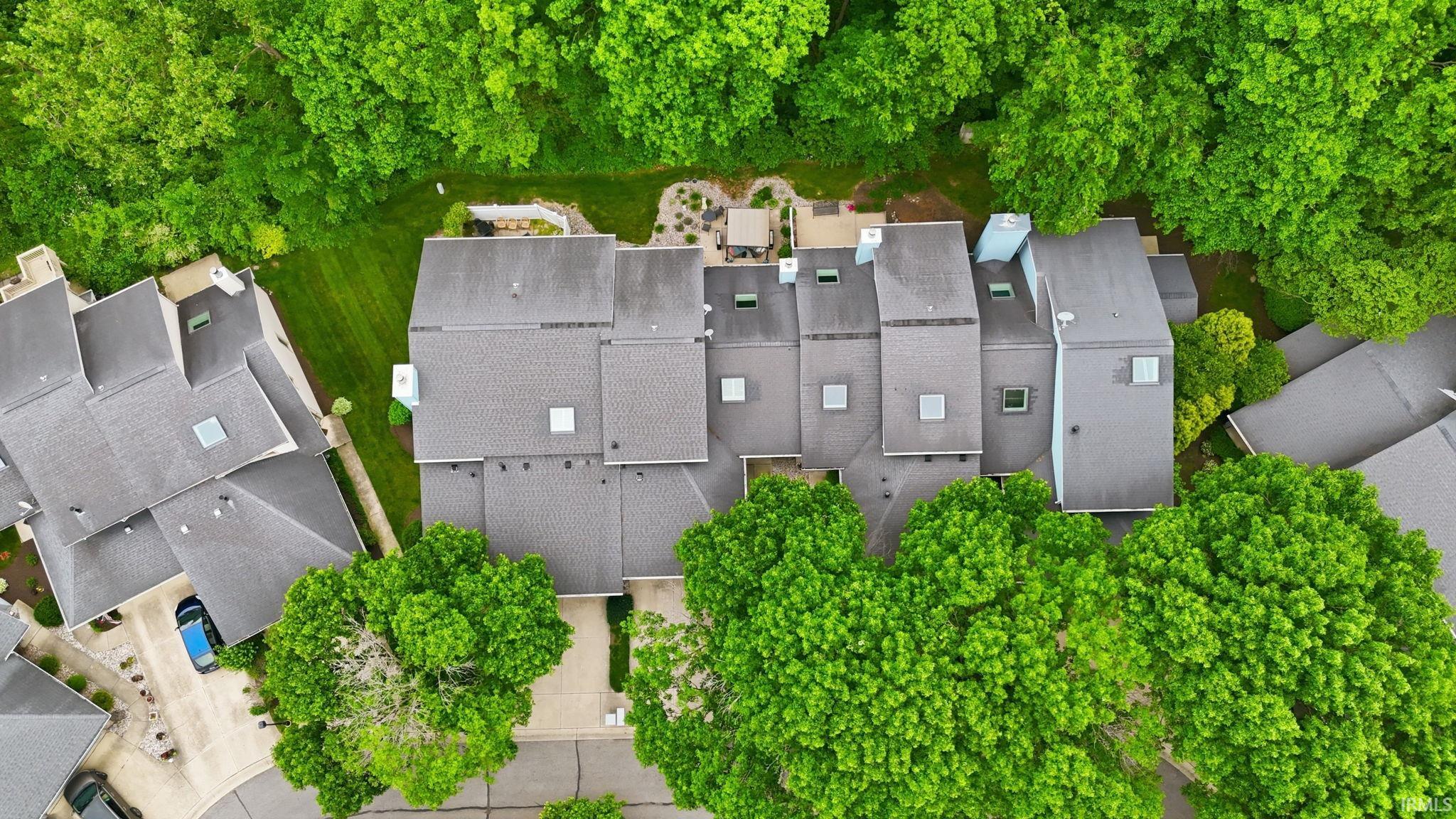 Contemporary multi-unit property with a dark grey shingle roof and multiple skylights