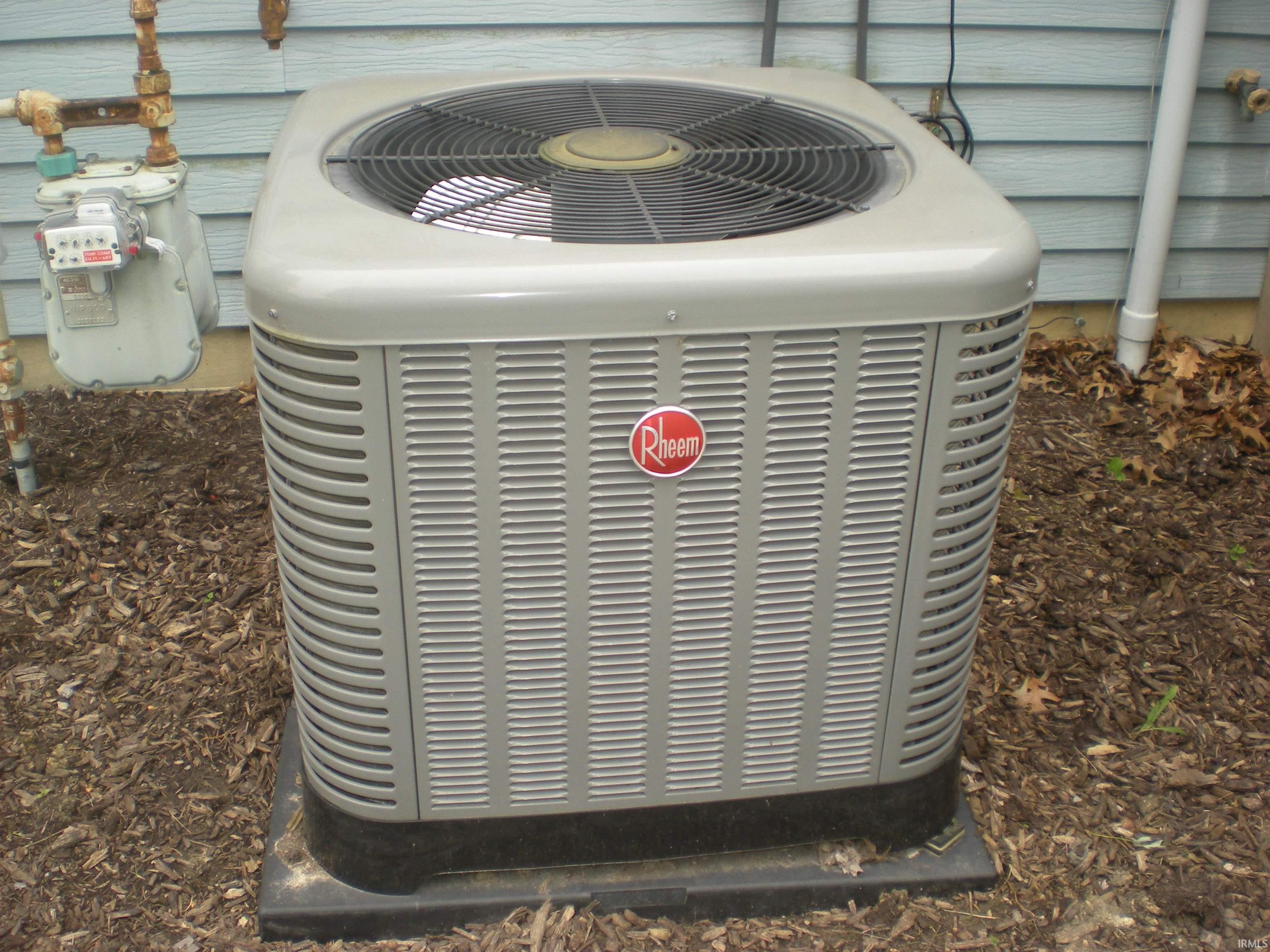 Rheem brand air conditioning unit on a dark pad foundation