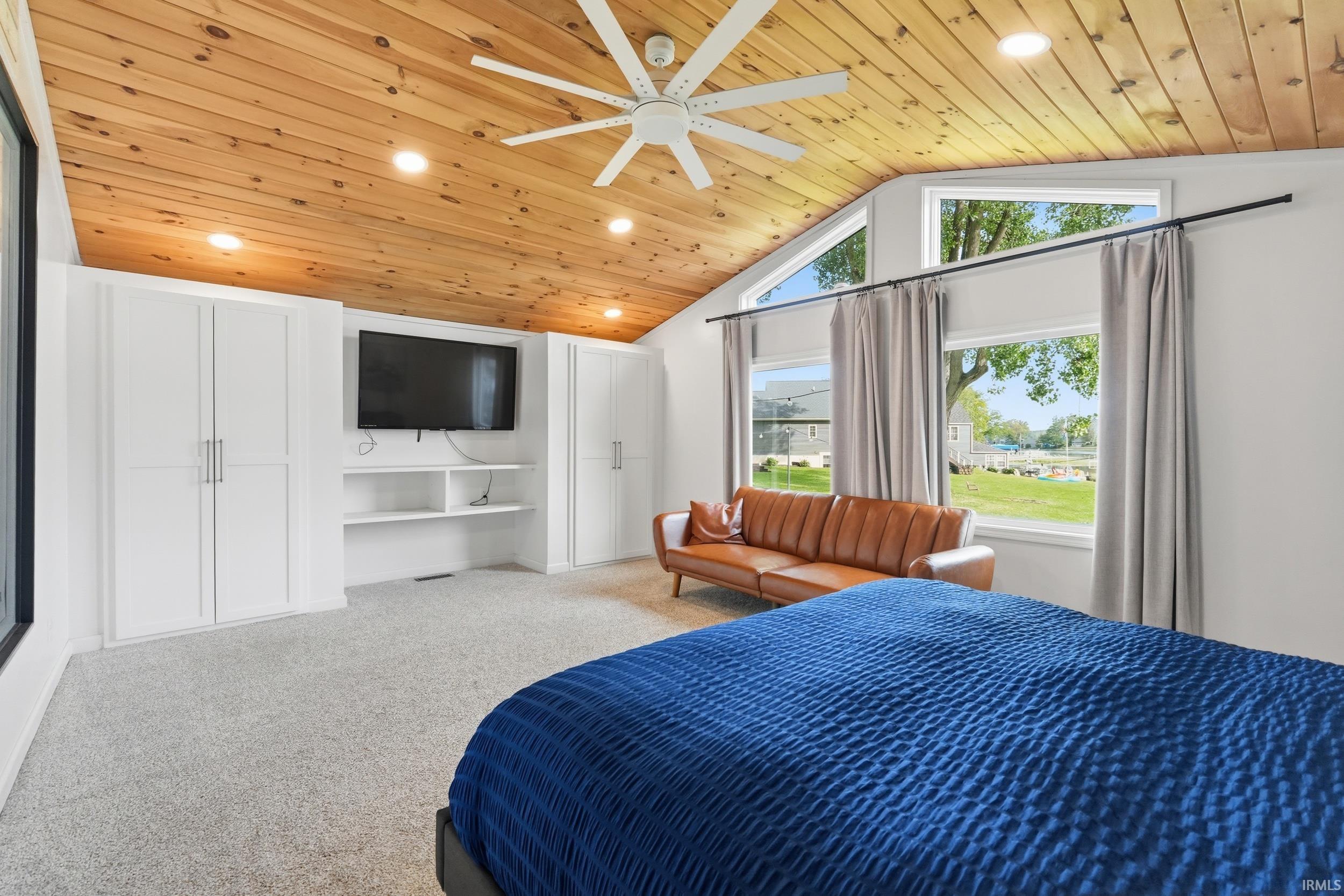 Vaulted wood-finish ceiling with recessed lighting and ceiling fan