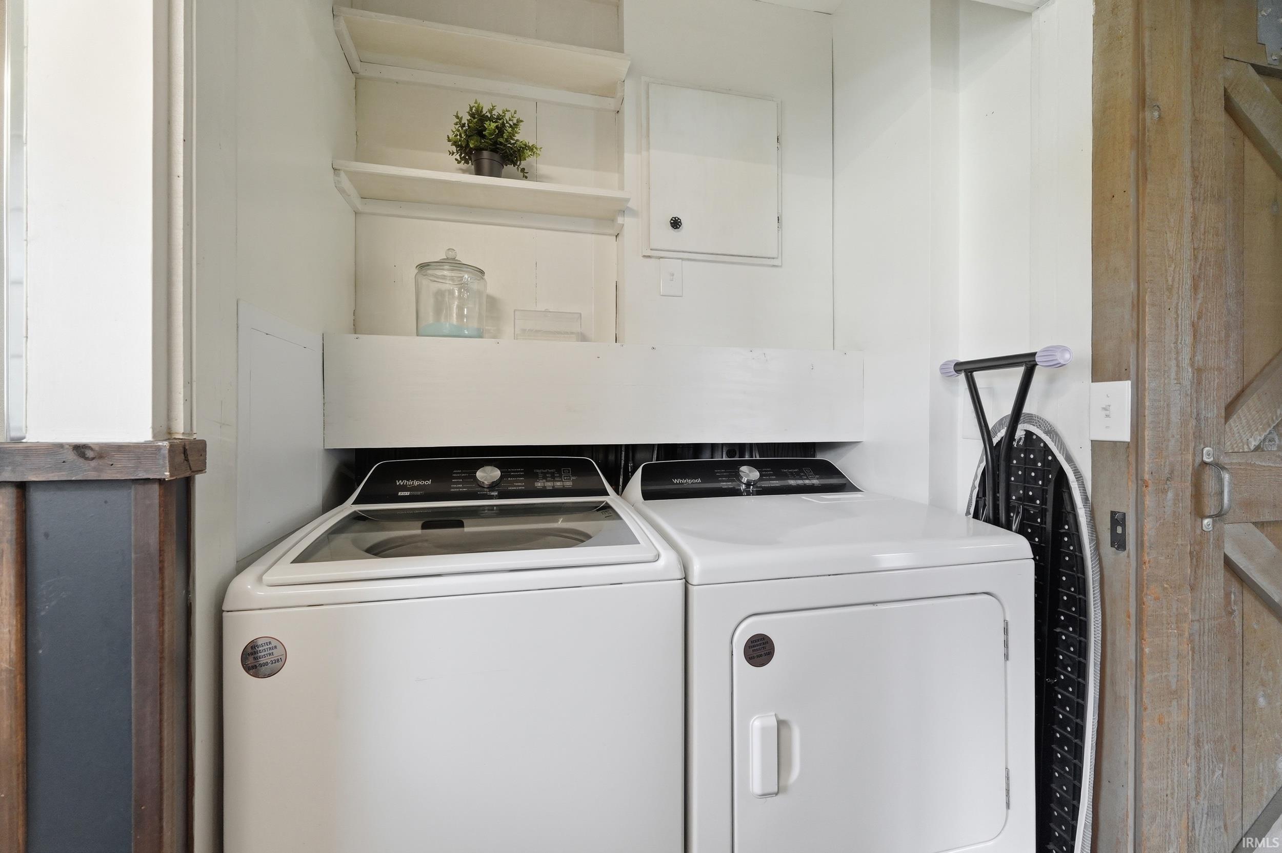 Dedicated laundry area featuring a white top-load washing machine and front-load dryer