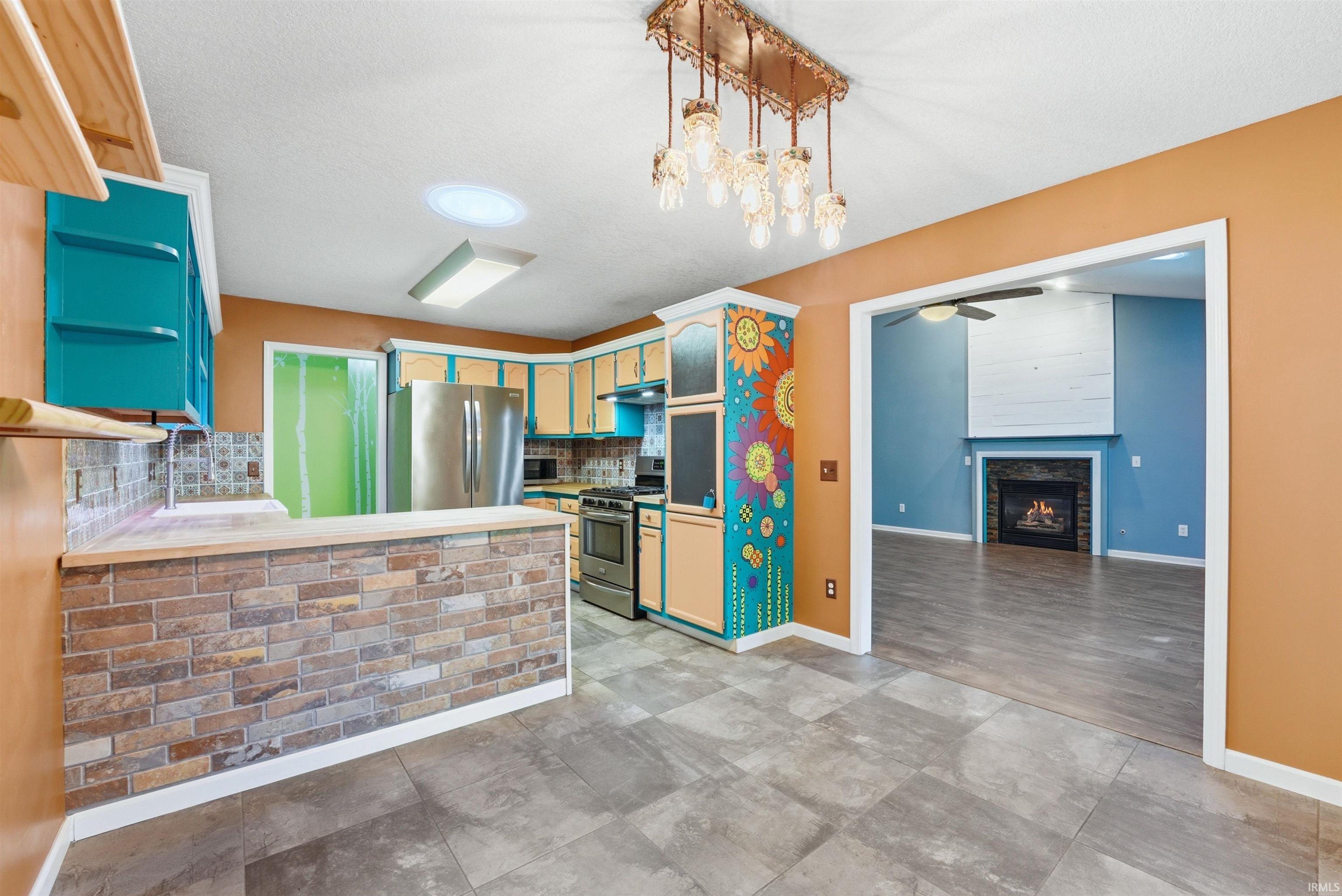 Kitchen area featuring a brick-style breakfast bar, tile flooring, and a decorative pendant light fixture