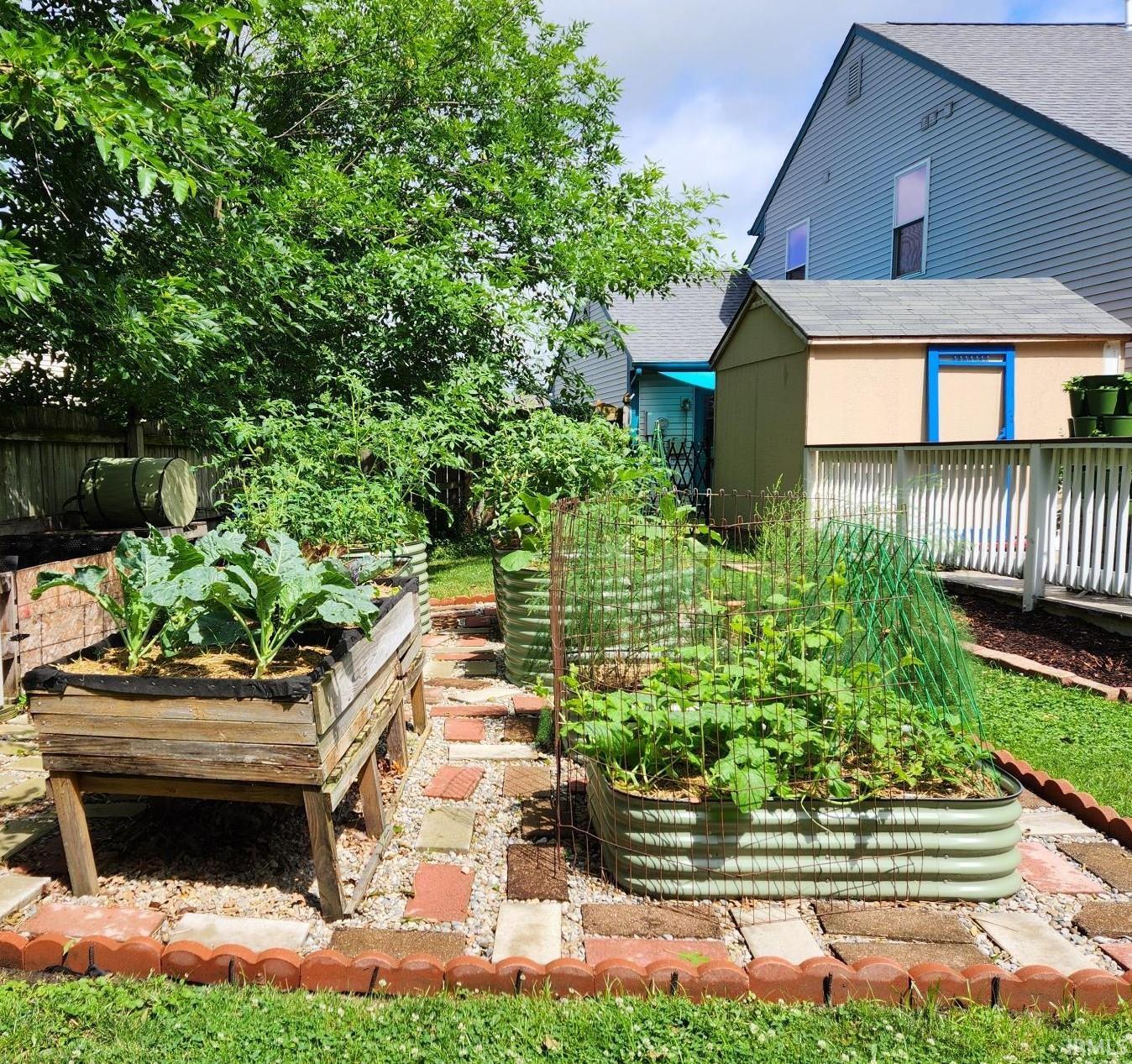 Backyard garden featuring elevated wood planters and corrugated metal raised garden beds