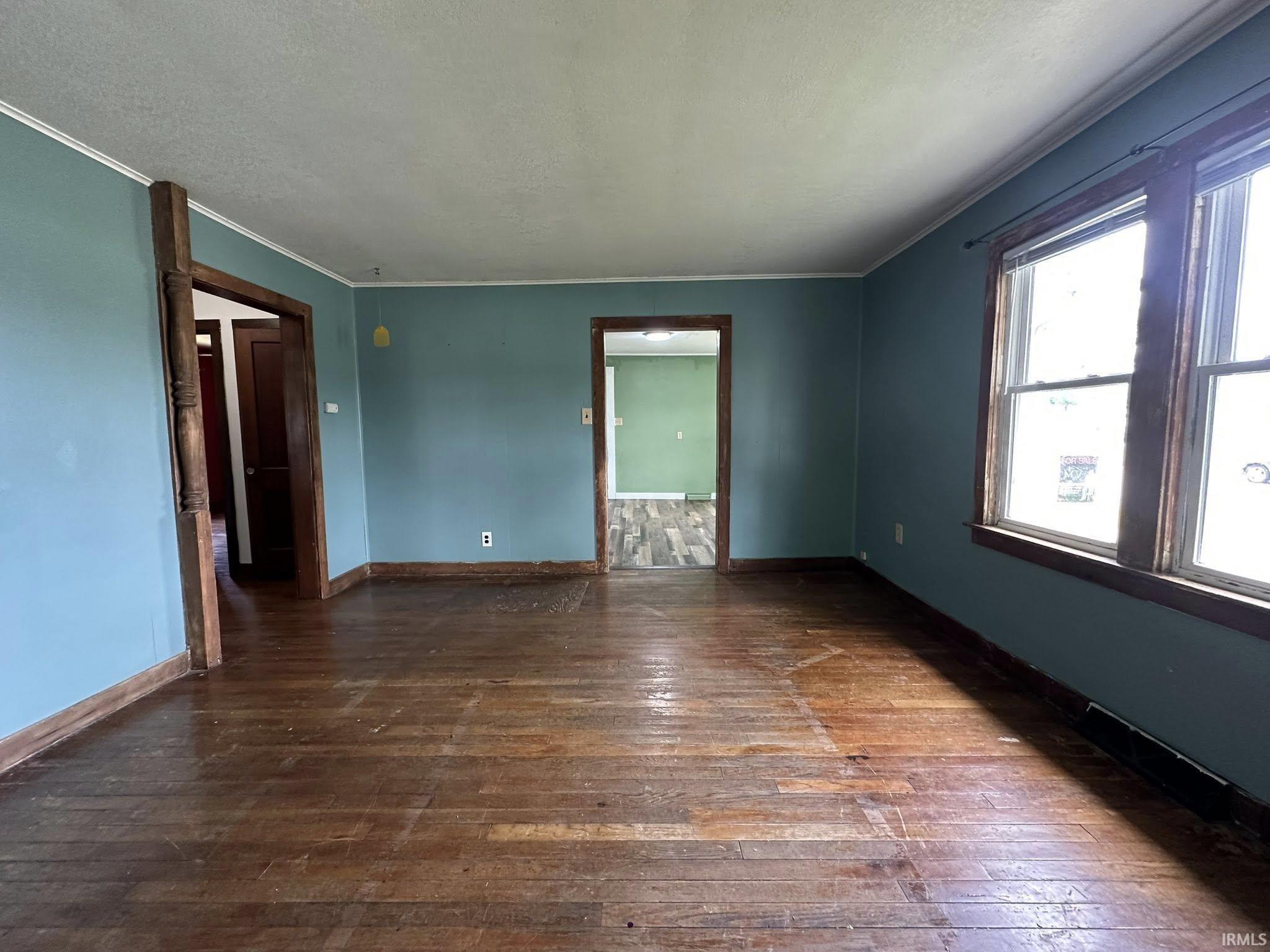 Hardwood flooring complemented by baseboard trim and window casing