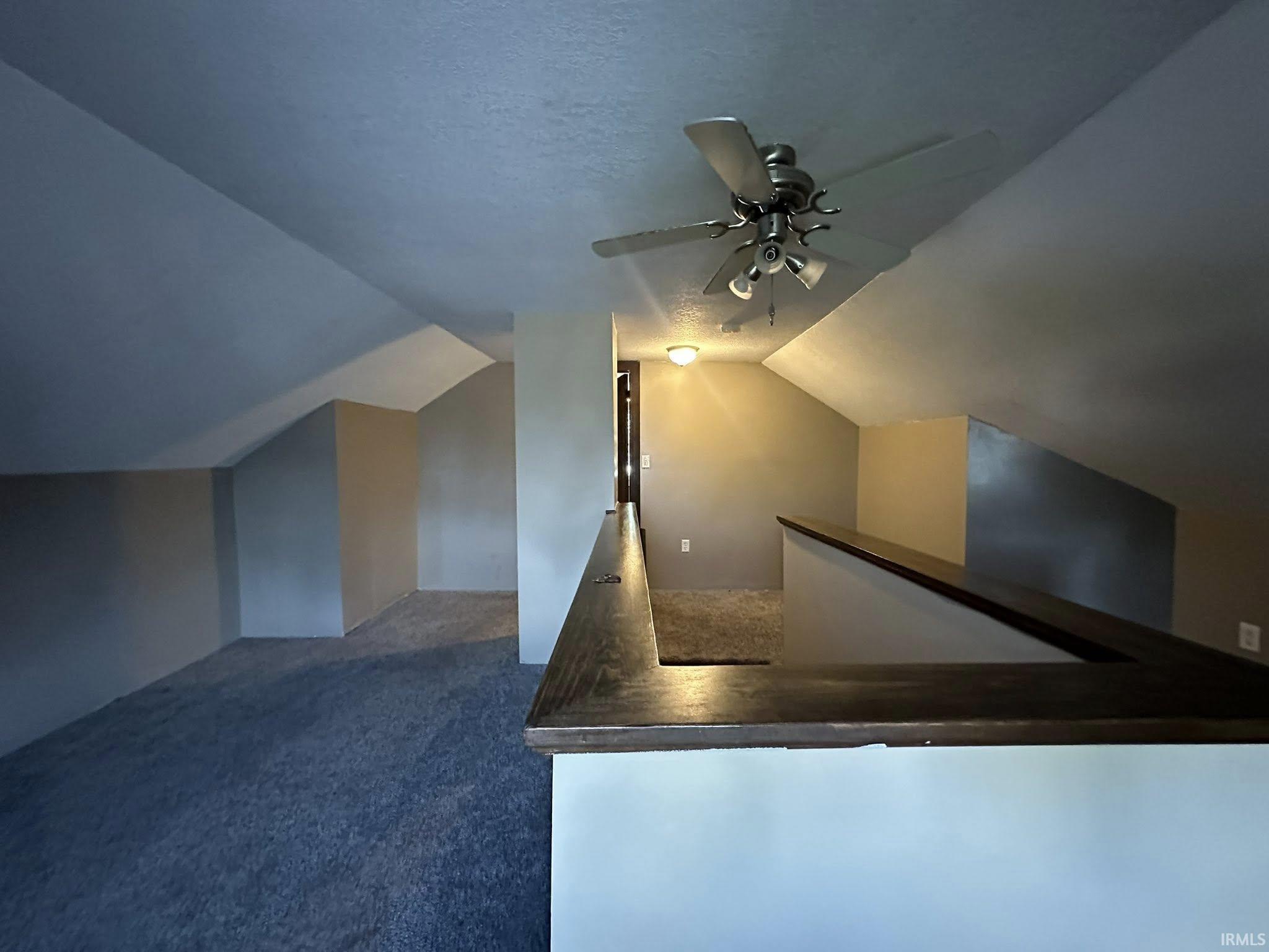 Loft area featuring sloped ceilings, recessed lighting, and a ceiling fan