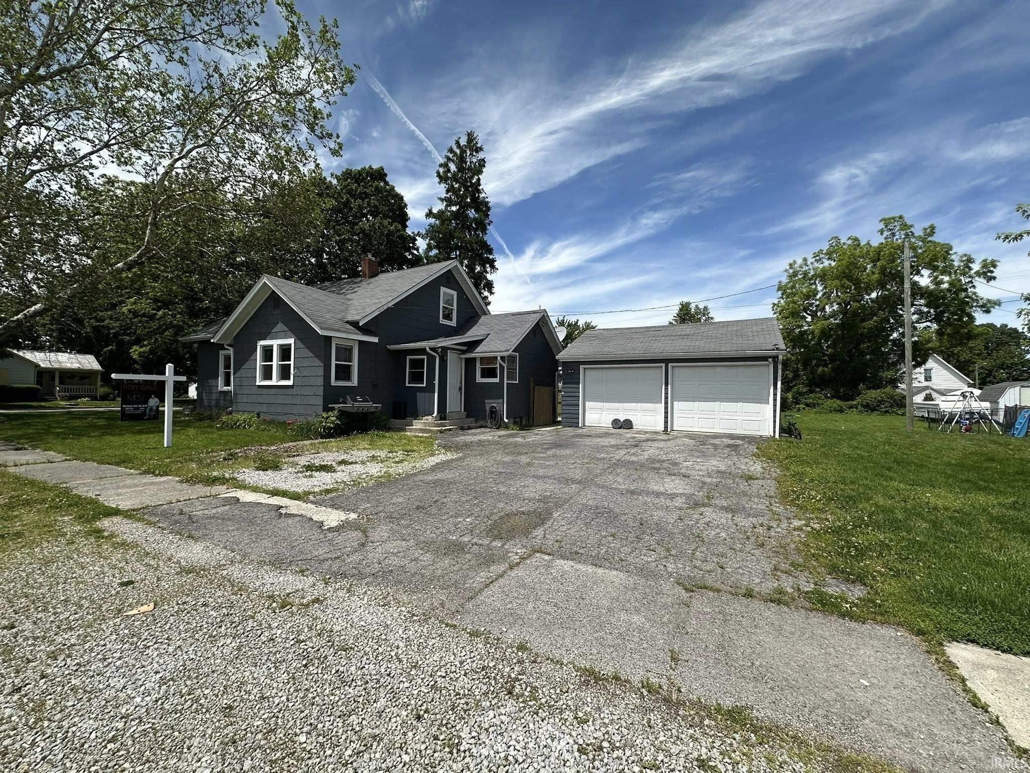 Exterior features a gray siding facade with white trim windows and a dark gray shingled roof