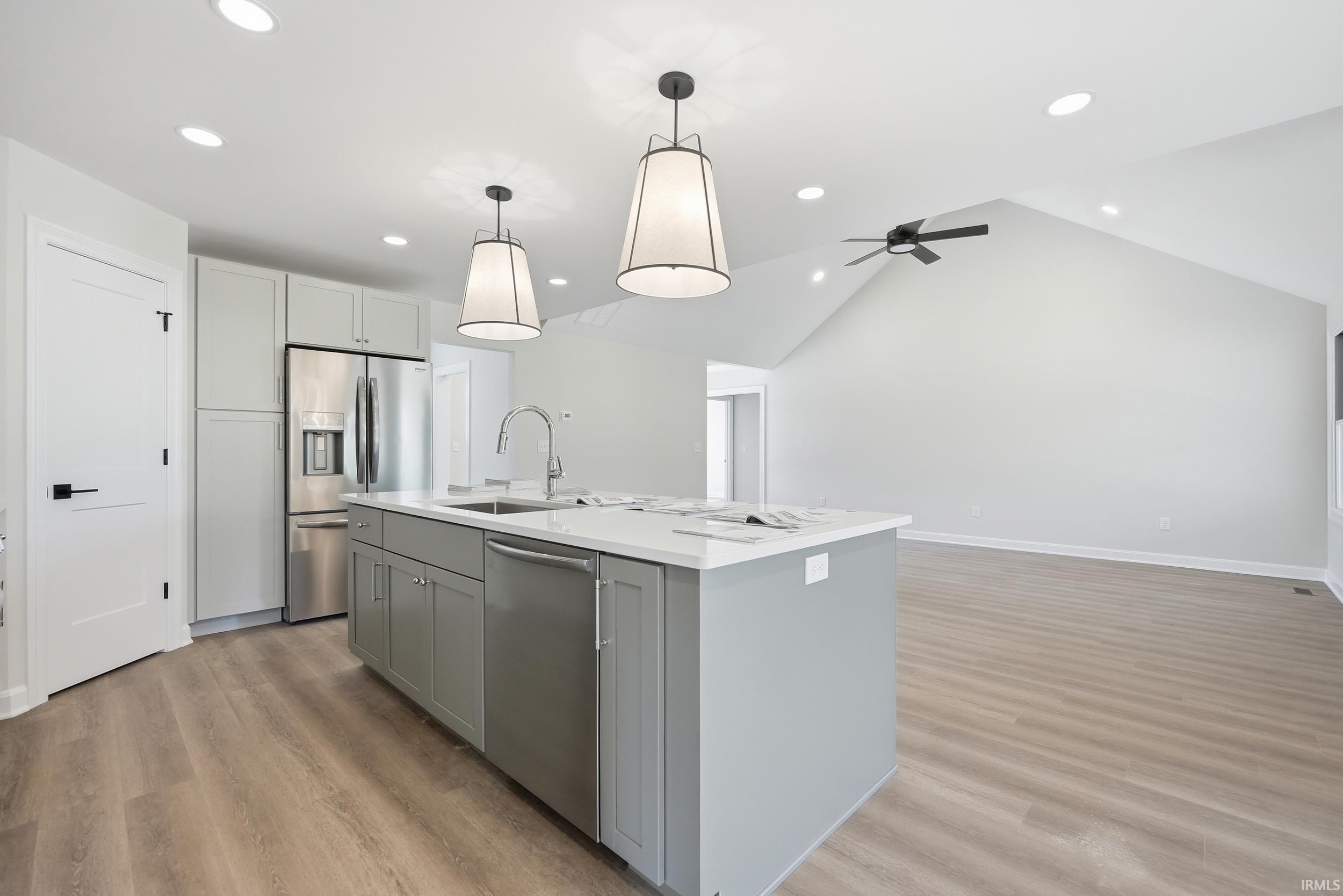Contemporary kitchen island with a white countertop and grey cabinetry