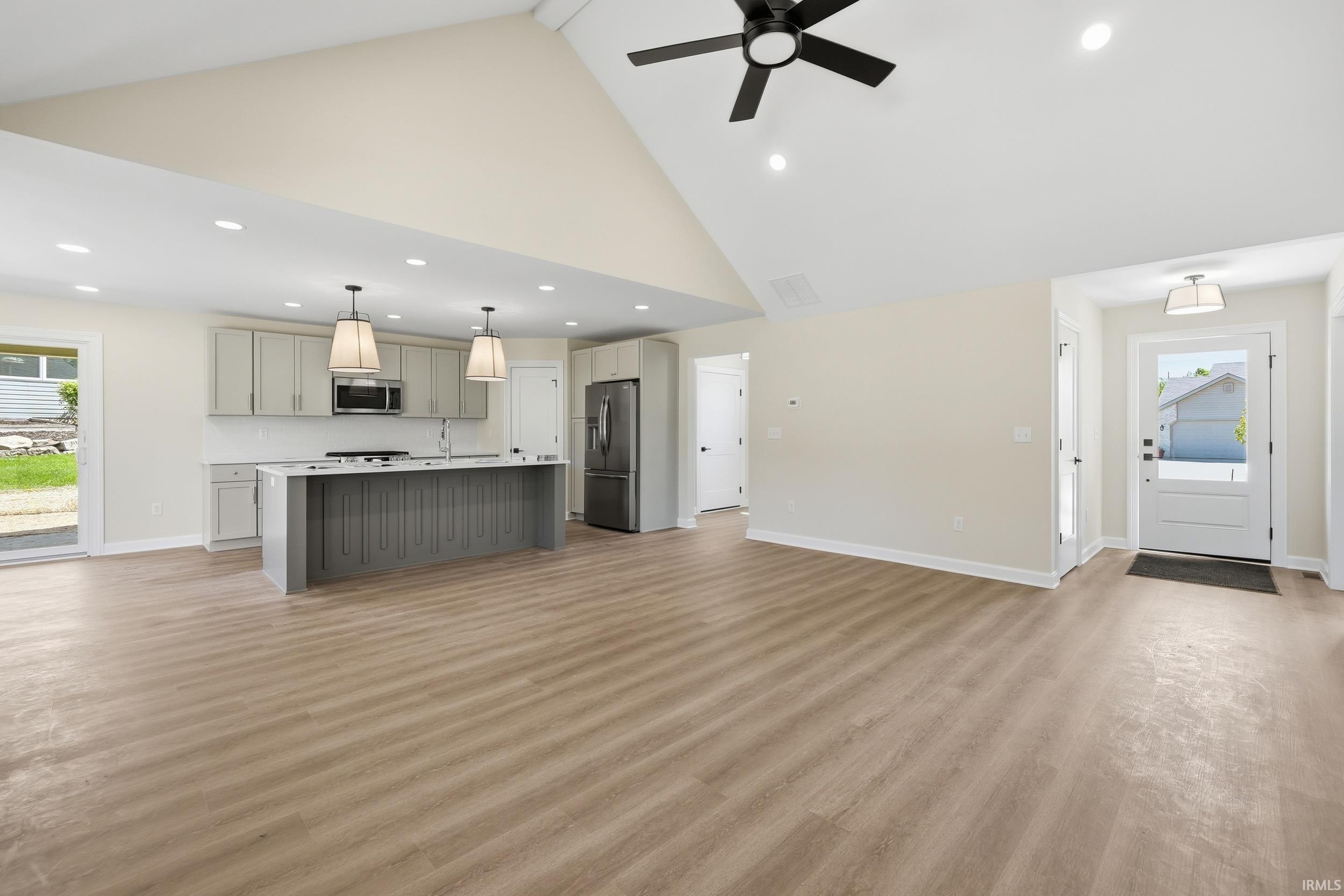 Open concept living area with vaulted ceilings and wood-finish flooring