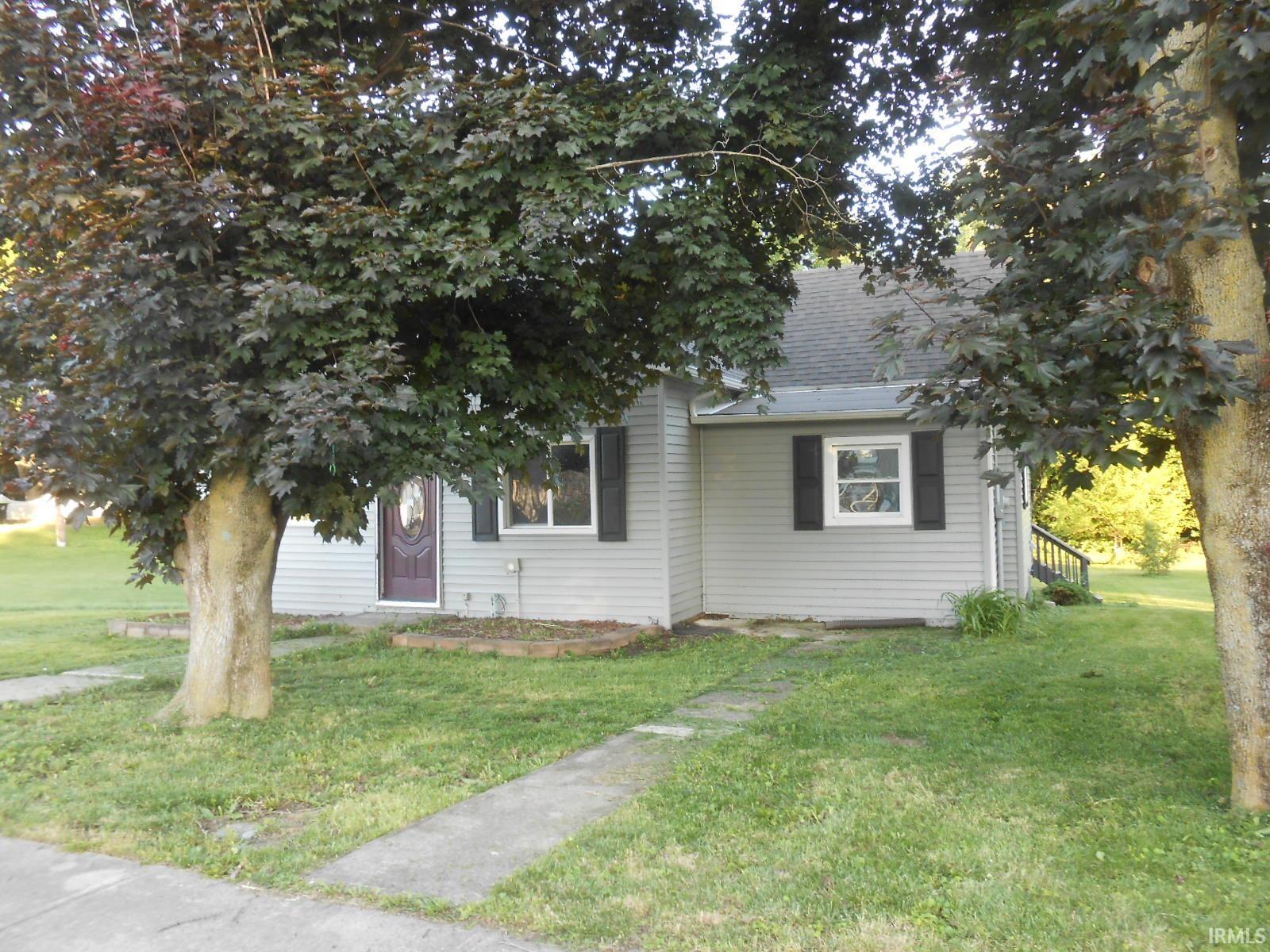 Gray siding exterior with a dark-paneled entry door