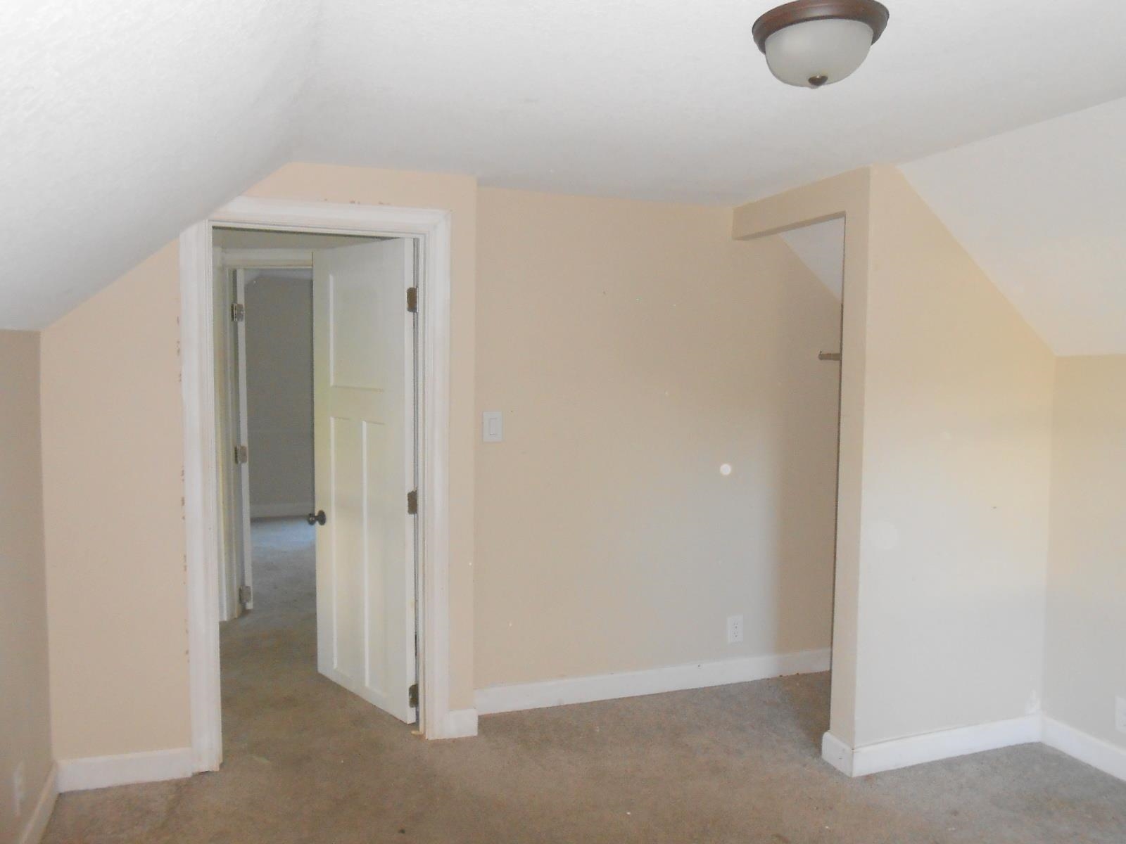 Interior room featuring neutral wall paint, white trim, and a semi-flush mount ceiling light