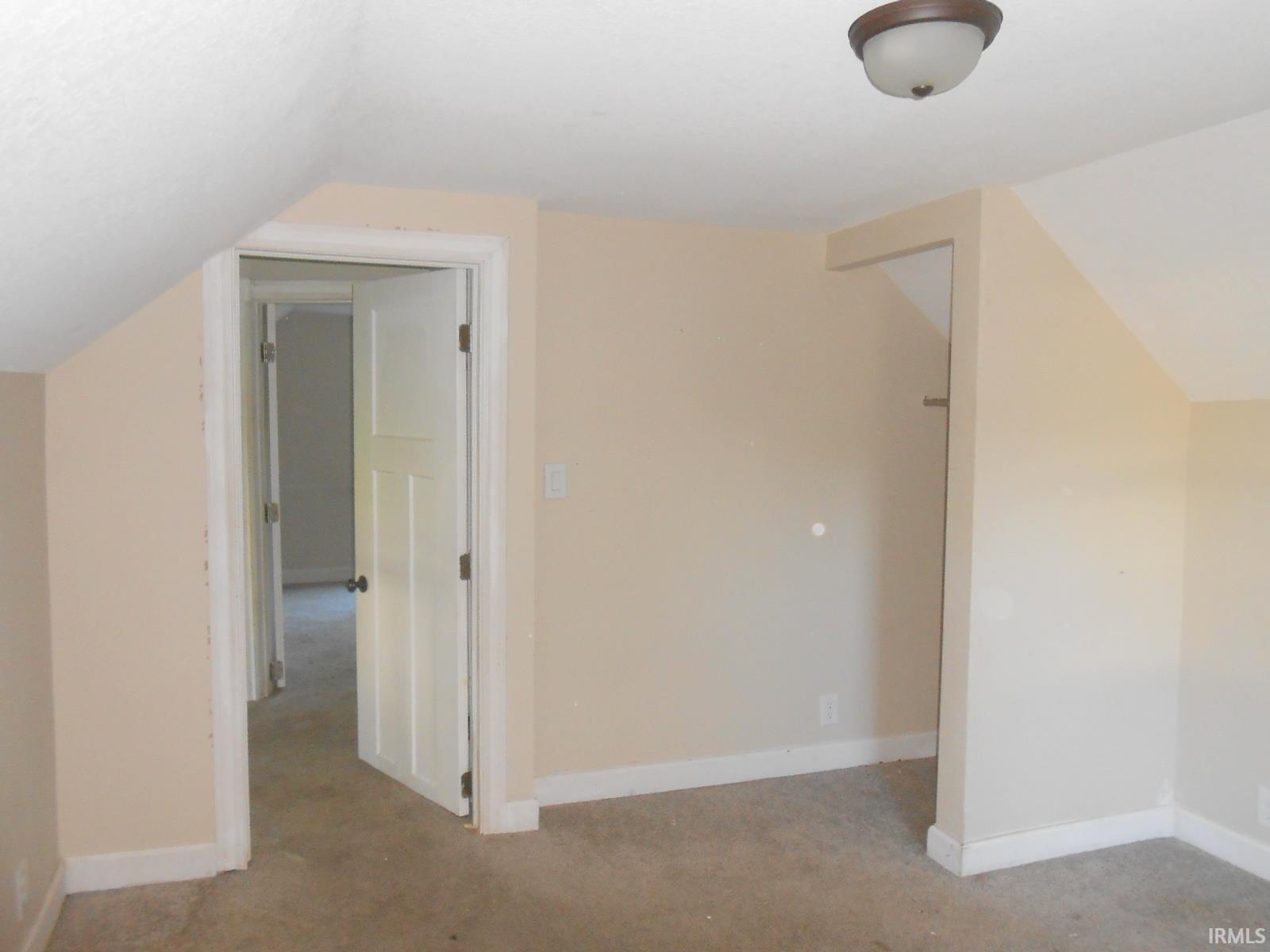 Interior room featuring neutral wall paint, white trim, and a semi-flush mount ceiling light