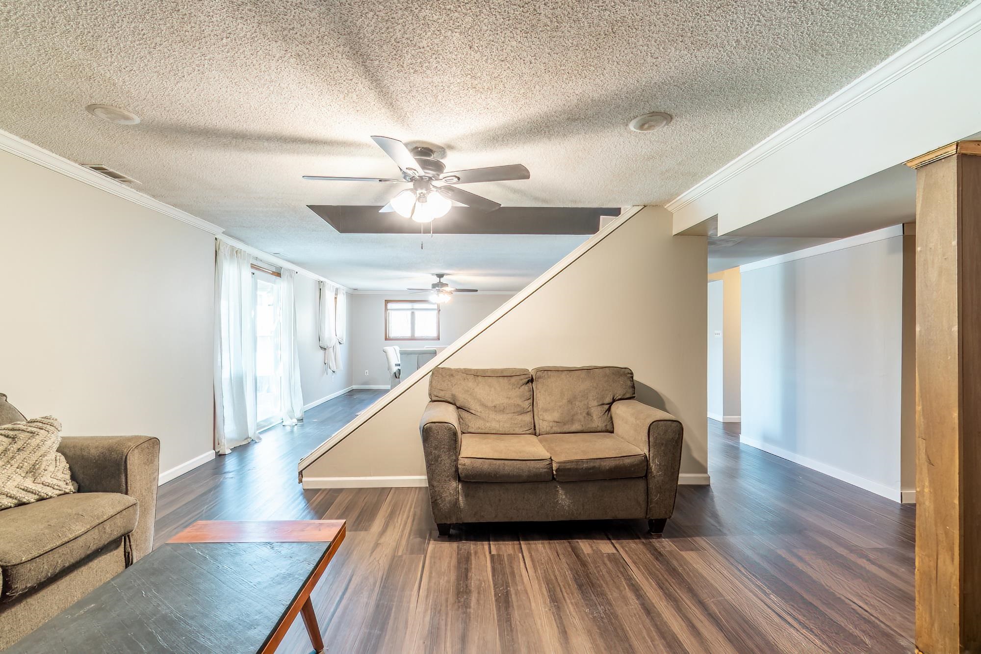 Spacious room featuring wood-finish flooring, a ceiling fan, and recessed lighting