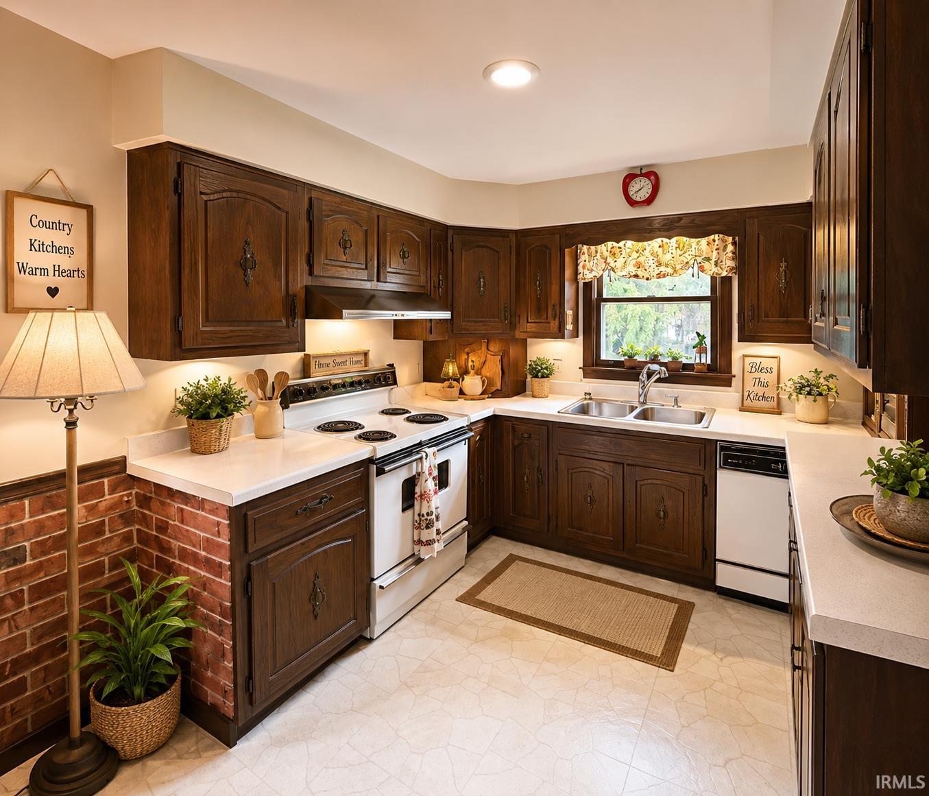U-shaped kitchen featuring dark wood cabinetry, white countertops, and a double basin sink Grabill Custom made Amish cabinets, Displaying original and virtually staged interior images of the property