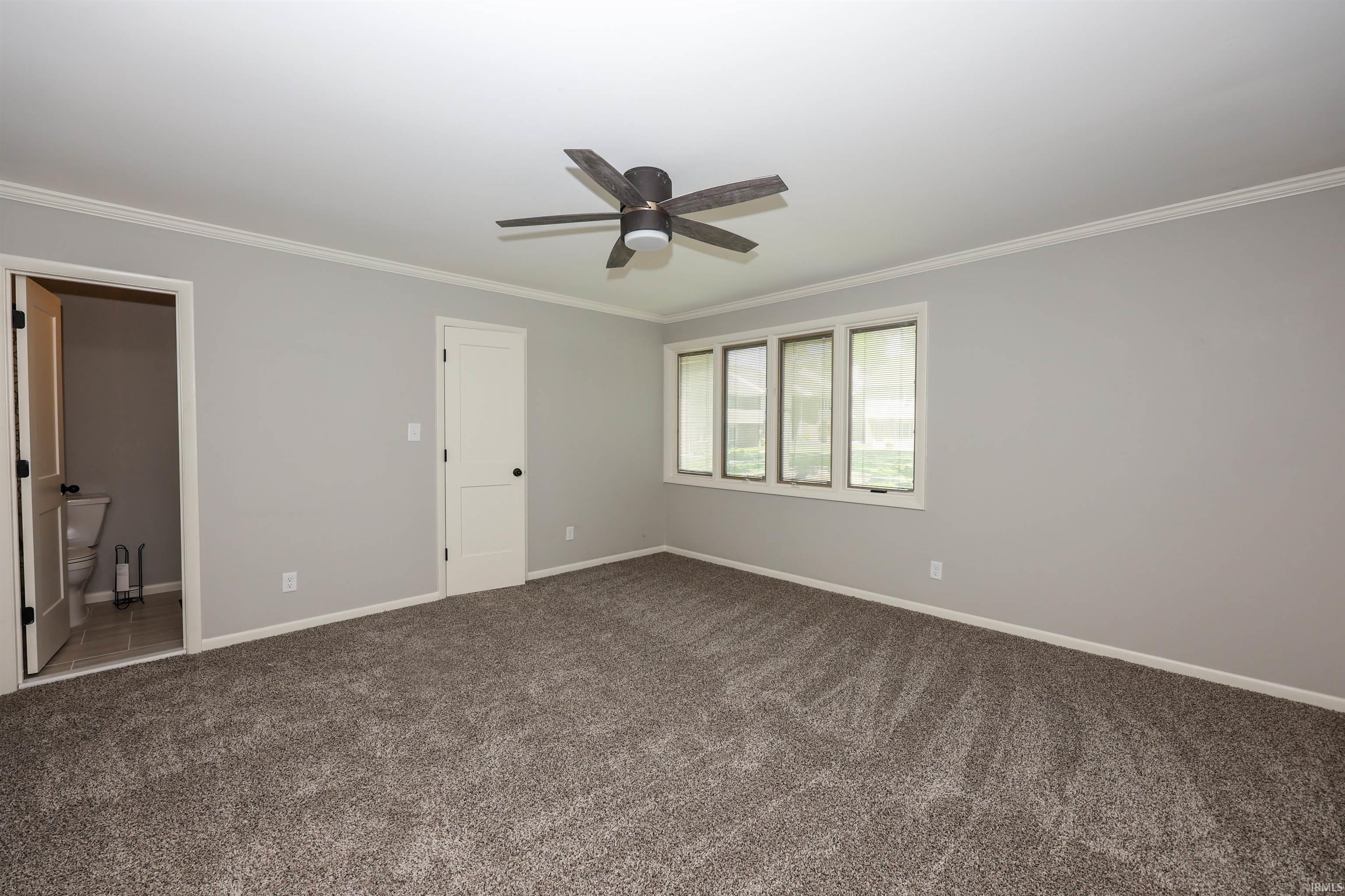 Spacious room with new carpeting, light gray wall paint, and white trim