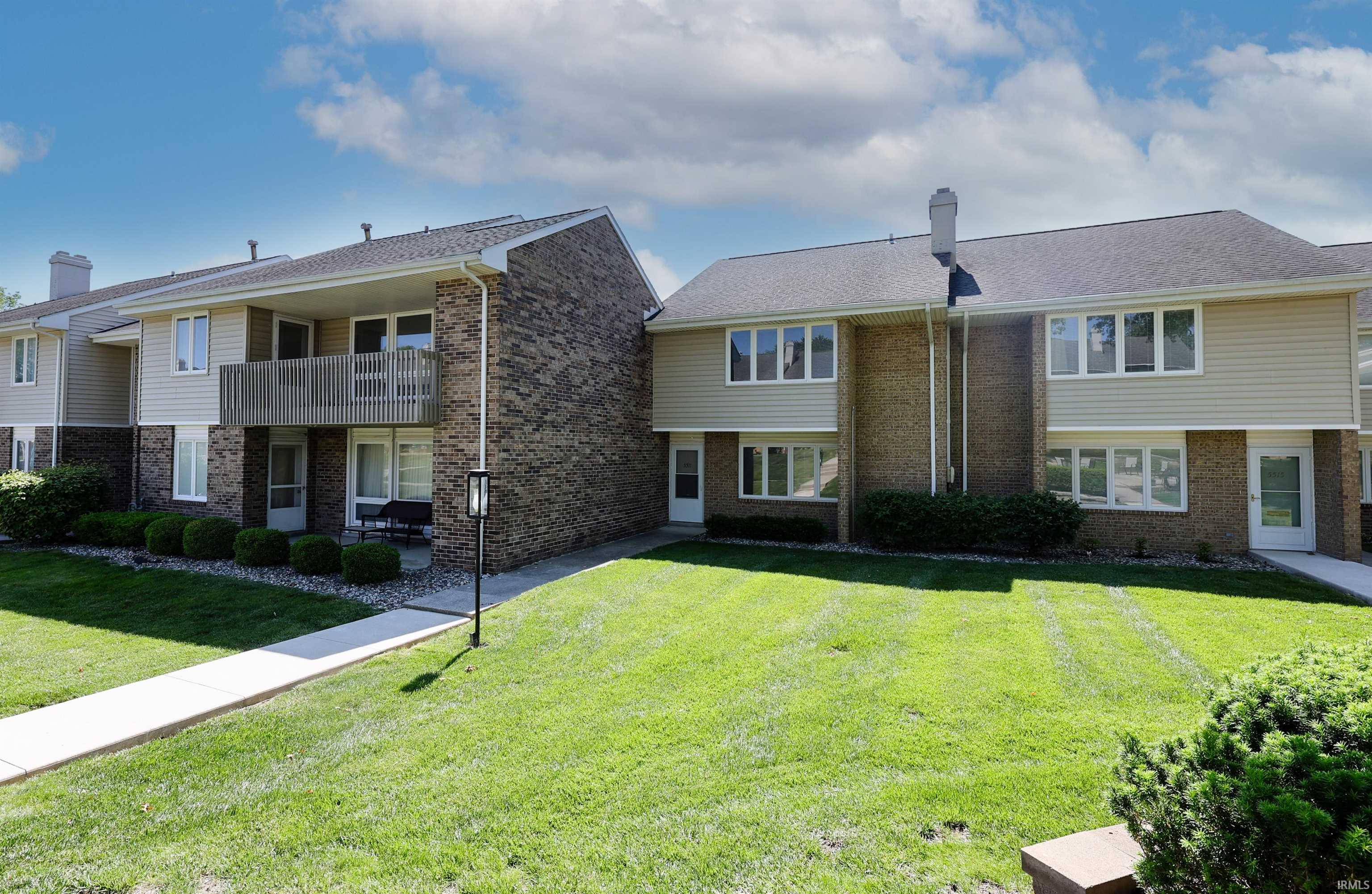 Multi-level exterior featuring light-toned siding and brick accents