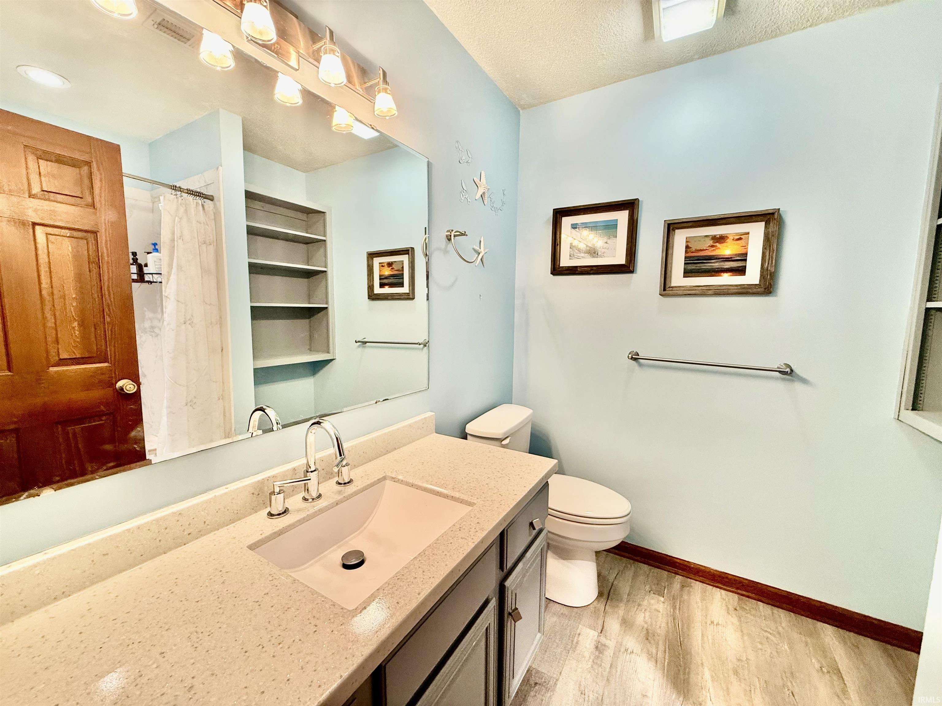 Bathroom featuring a vanity with an integrated sink, polished chrome faucet, and a light-toned countertop
