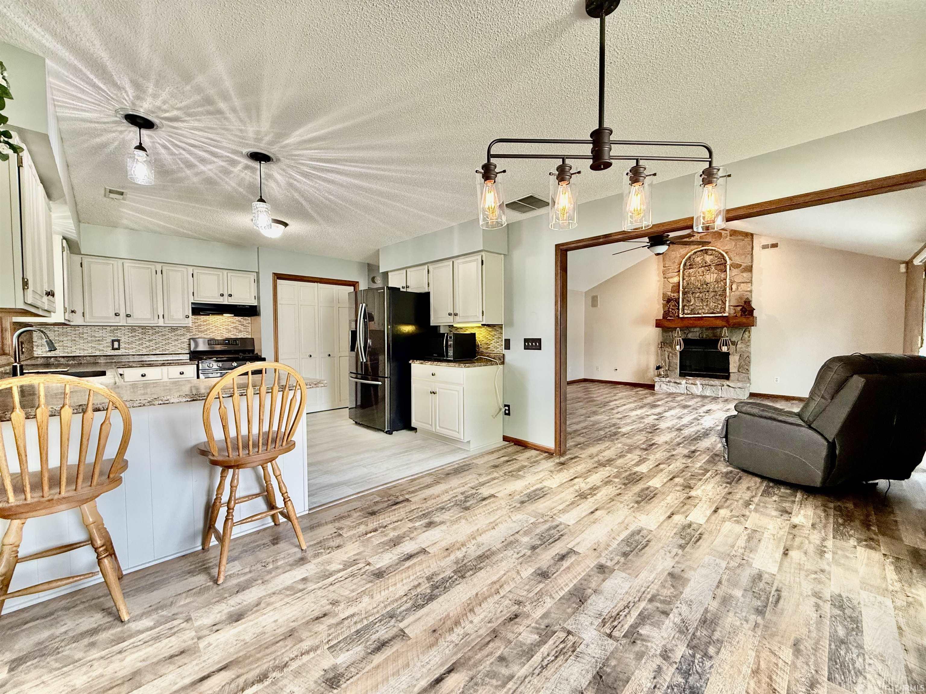 Open-concept kitchen and living area featuring wood-finish flooring