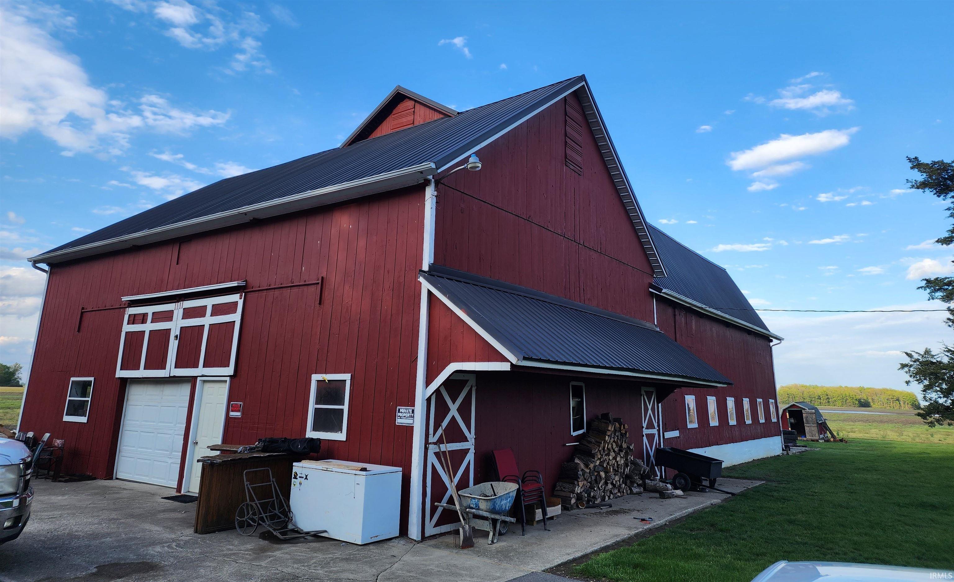 Red barn structure featuring a black metal roof and white trim