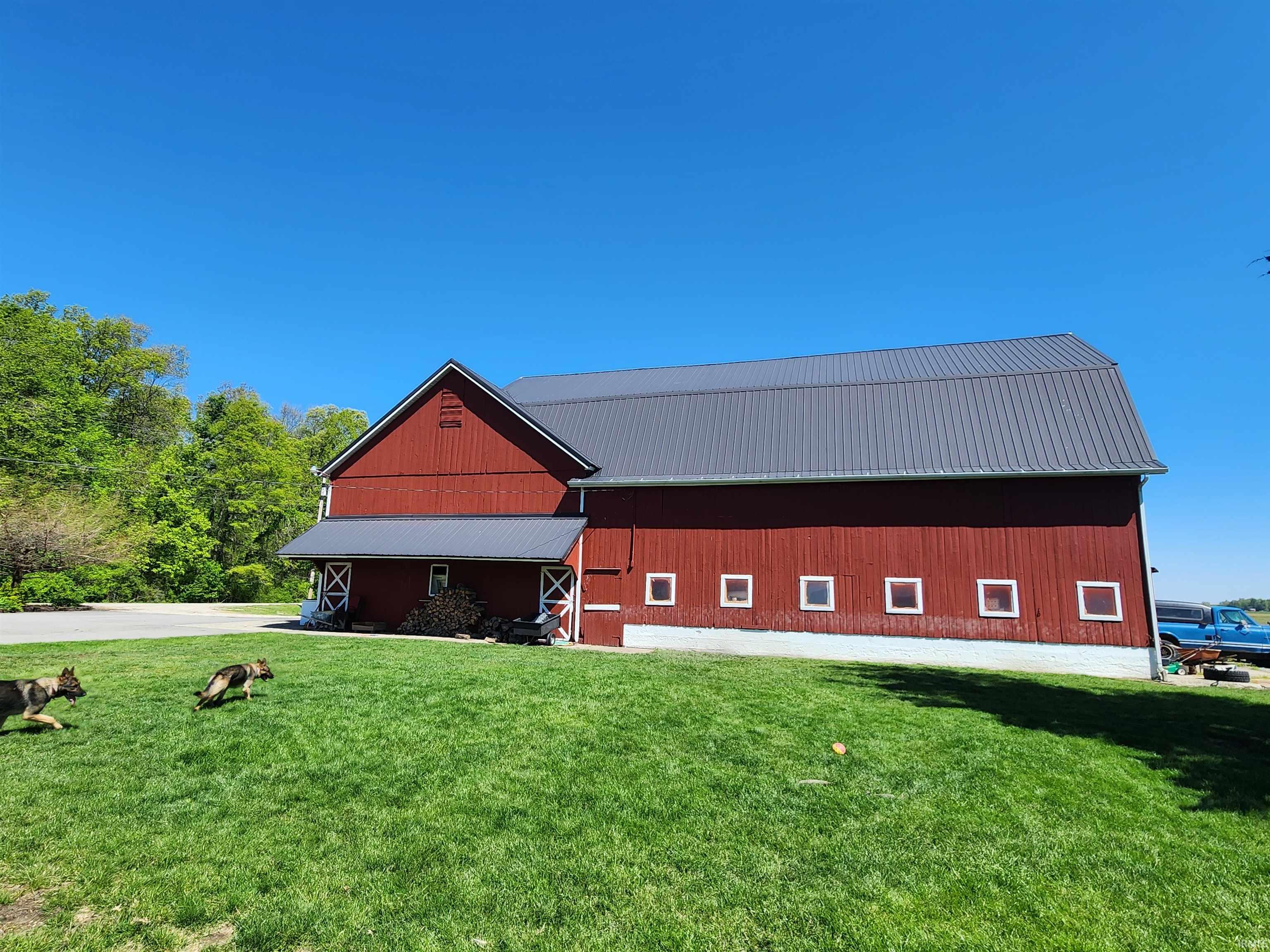 Red barn structure featuring a gabled roofline and a dark metal roof