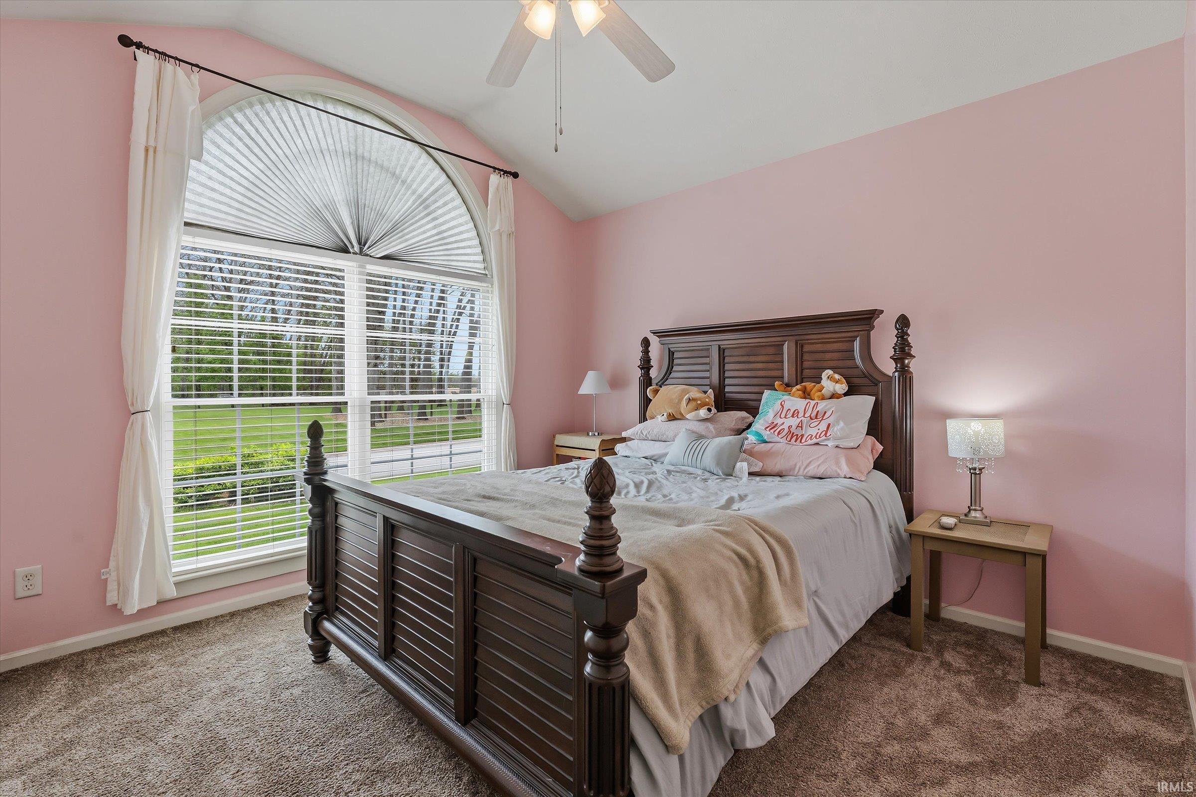 Room featuring an arched window with blinds, ceiling fan, and carpeted flooring