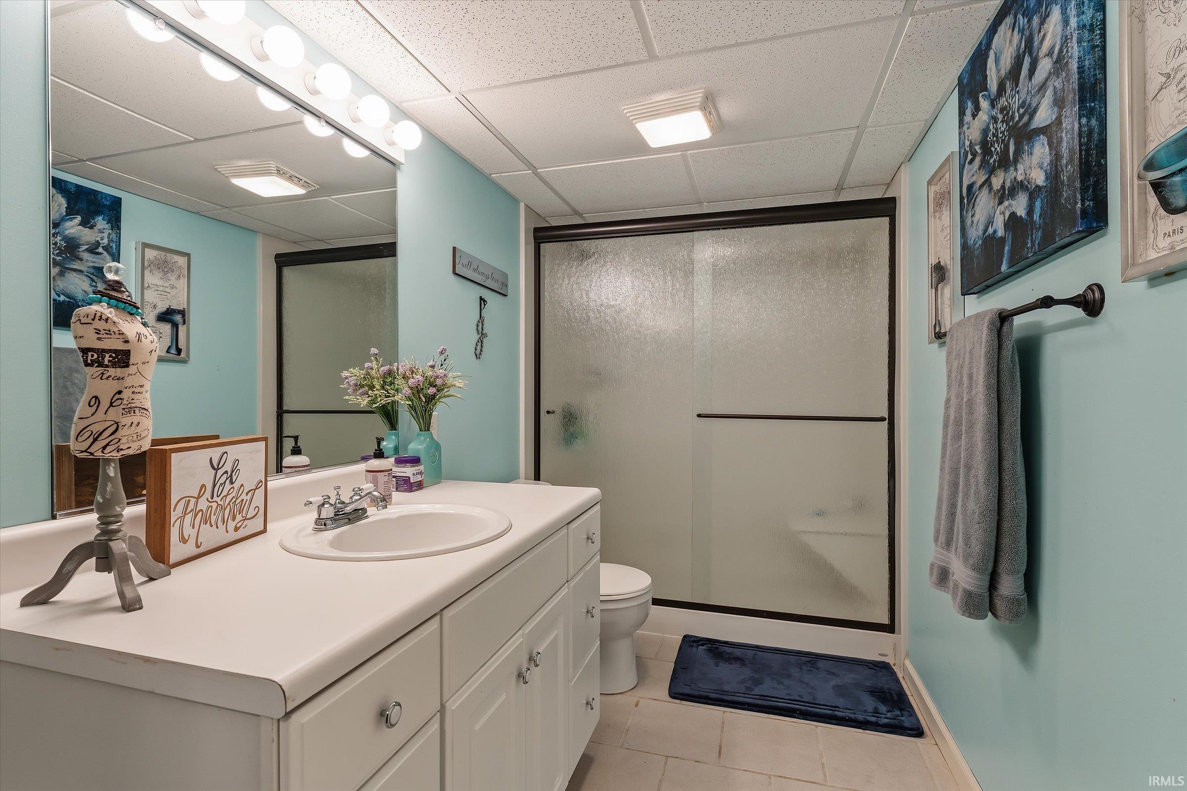 Bathroom featuring a white vanity with integrated sink, chrome faucet, and cabinet storage