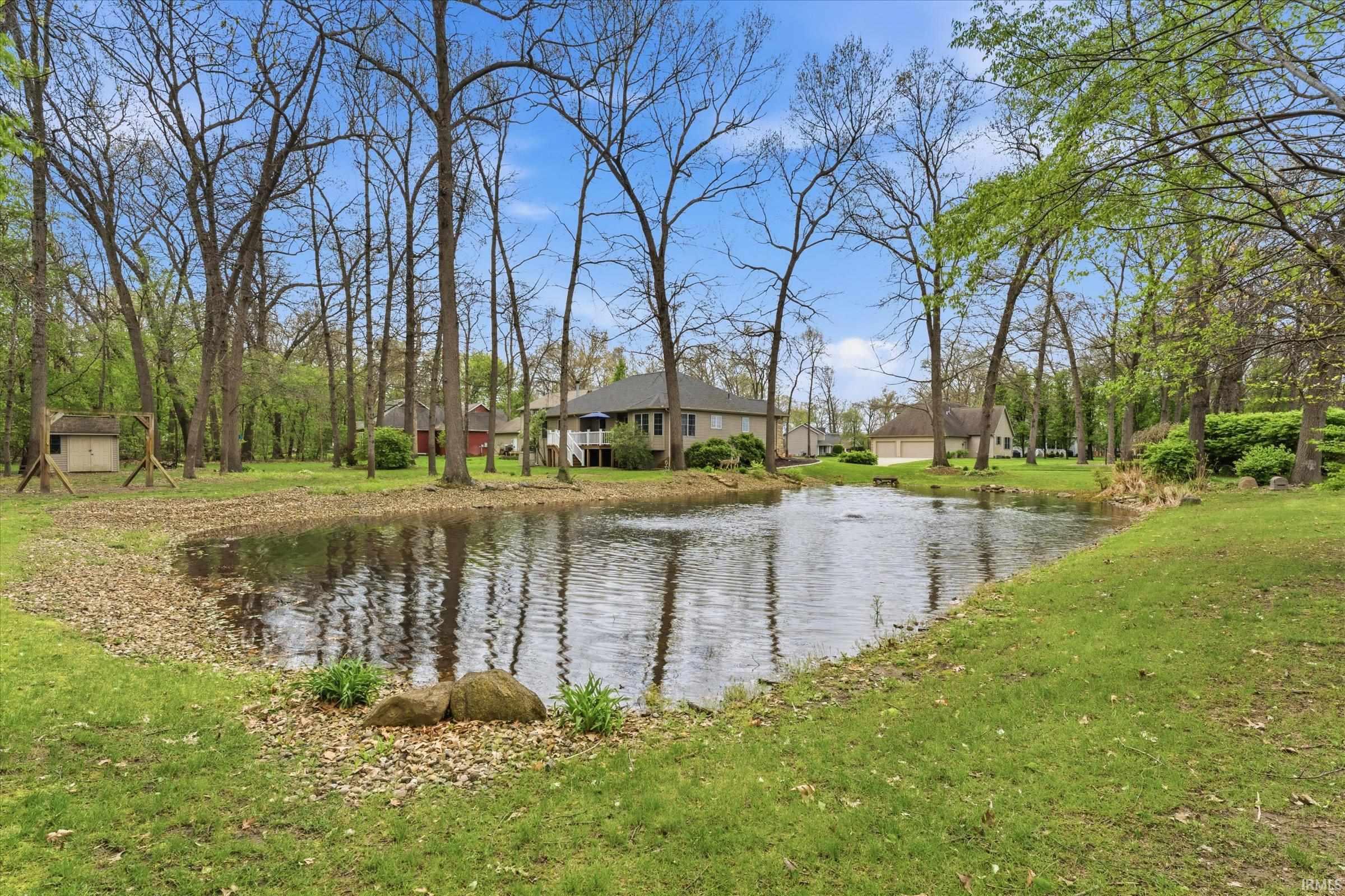 Private pond with a fountain feature, surrounded by mature trees and verdant lawns